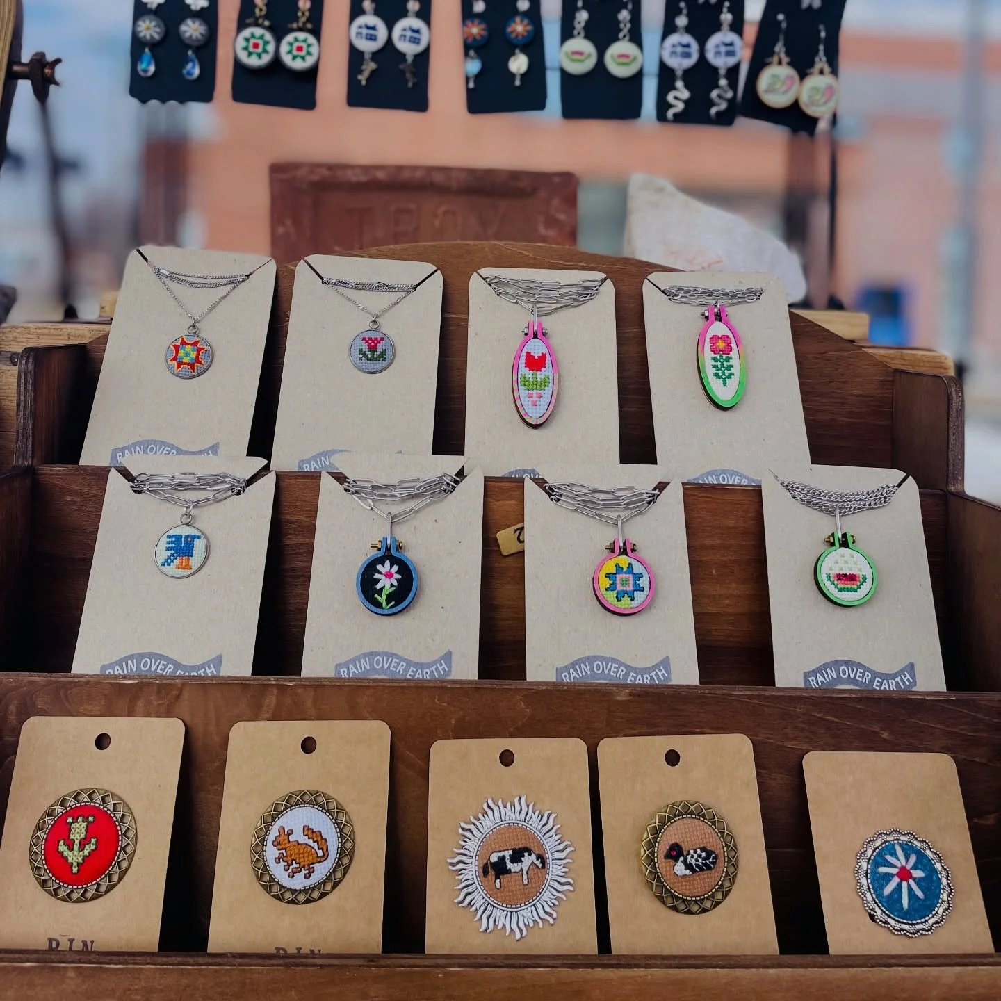 Tiny art. Big personality.

These little stitched pins are basically wearable love notes to the land &mdash; cows, birds, flowers, vegetables, tiny scenes that feel like they belong in a storybook.

They&rsquo;re the kind of thing you pin to a denim 