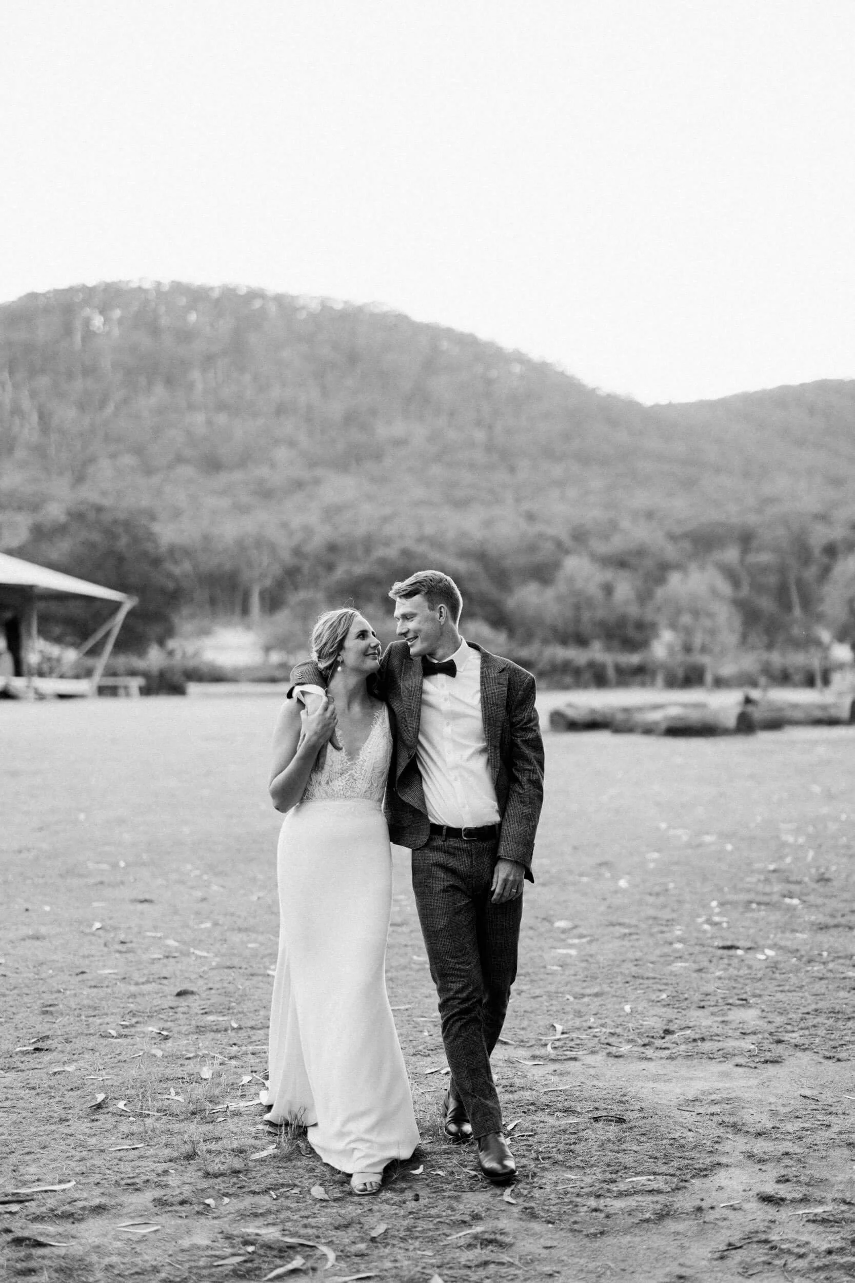 A couple walk together in a quiet, relaxed black-and-white wedding portrait in regional Victoria.