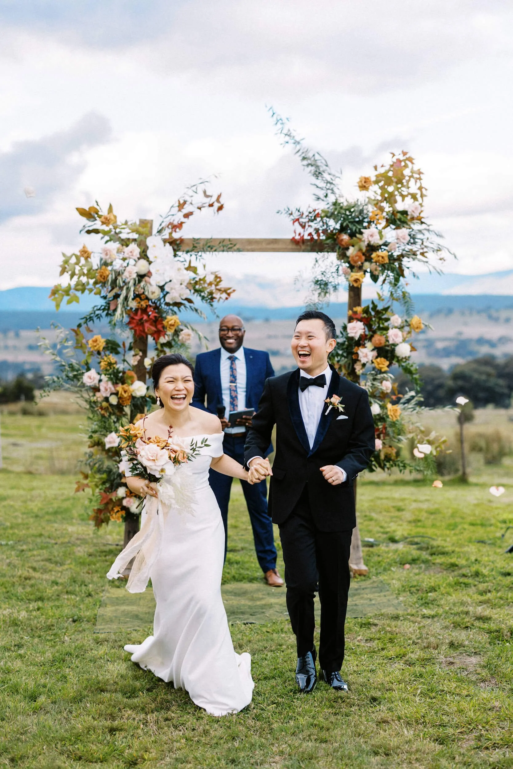 A newlywed couple celebrate as they walk down the aisle at a mountain-top wedding in Mount Bulla