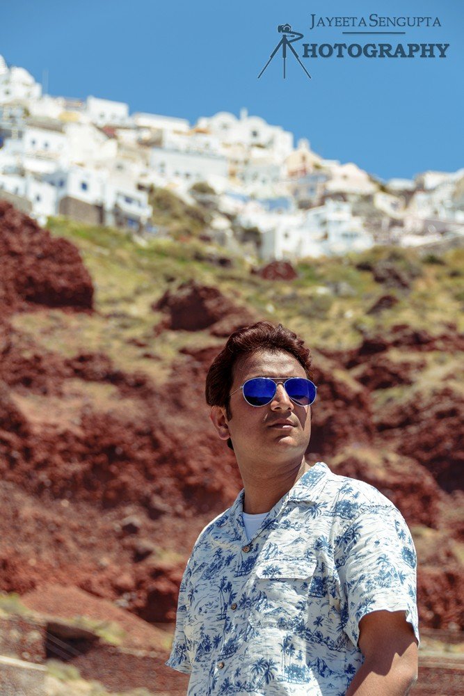man standing at ammoudi harbor with white houses church blue domes oia imerovigli firostefani fira village santorini greece caldera volcanic island