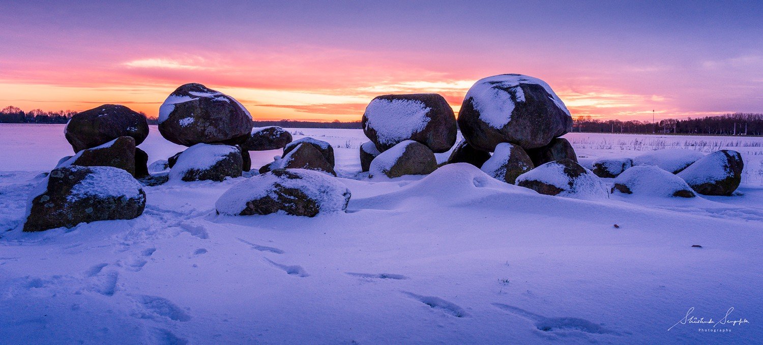 snow around village houses windmills and farms near dolmen hunebedden 15 drenthe netherlands at sunset