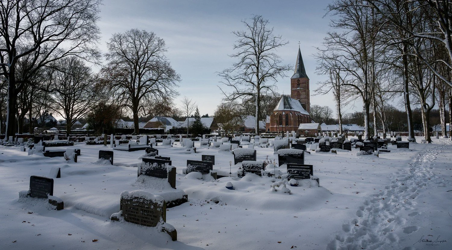 snow around village houses windmills and farms near dolmen hunebedden drenthe netherlands at sunset