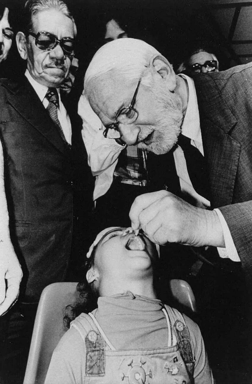 Albert Sabin administering oral polio vaccine to a child
