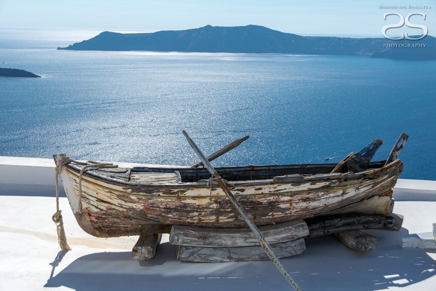 wooden boat near white houses church blue domes oia imerovigli firostefani fira village santorini greece caldera volcanic island