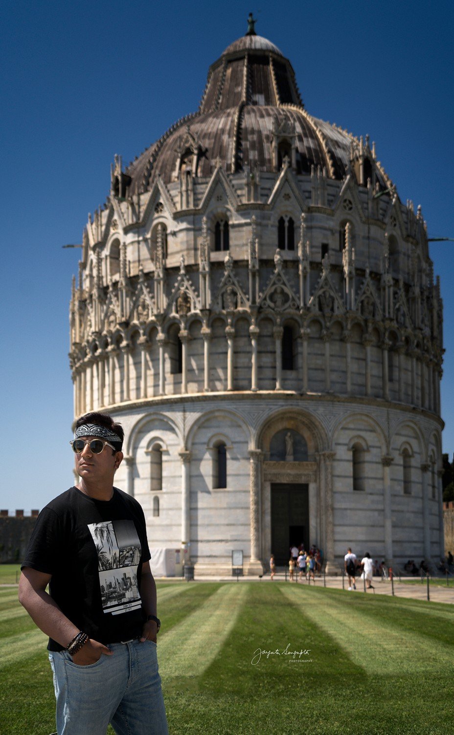 portrait of man standing in front of pisa baptistry cathedral and leaning clock tower in pisa tuscany italy shot in summer