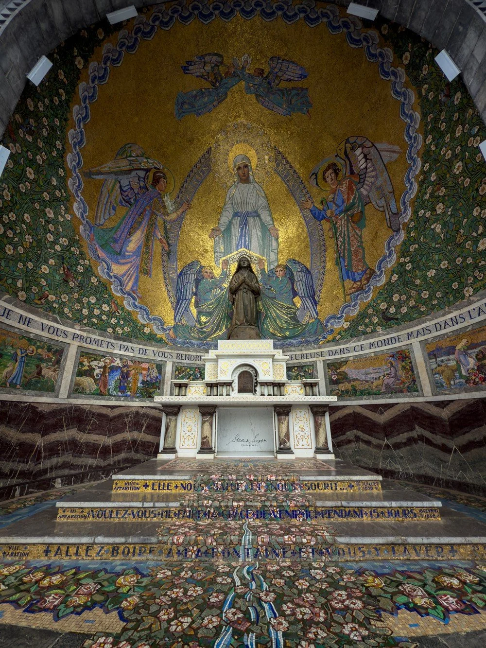 pilgrimage in the city of lourdes france dedicated to Lady Virgin Mary also known as Immaculate Conception who gave apparition to St. Bernadette featuring sanctuary church basilica grotto cave miraculous water and Marian procession
