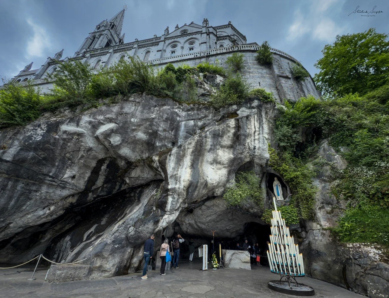 pilgrimage in the city of lourdes france dedicated to Lady Virgin Mary also known as Immaculate Conception who gave apparition to St. Bernadette featuring sanctuary church basilica grotto cave miraculous water and Marian procession