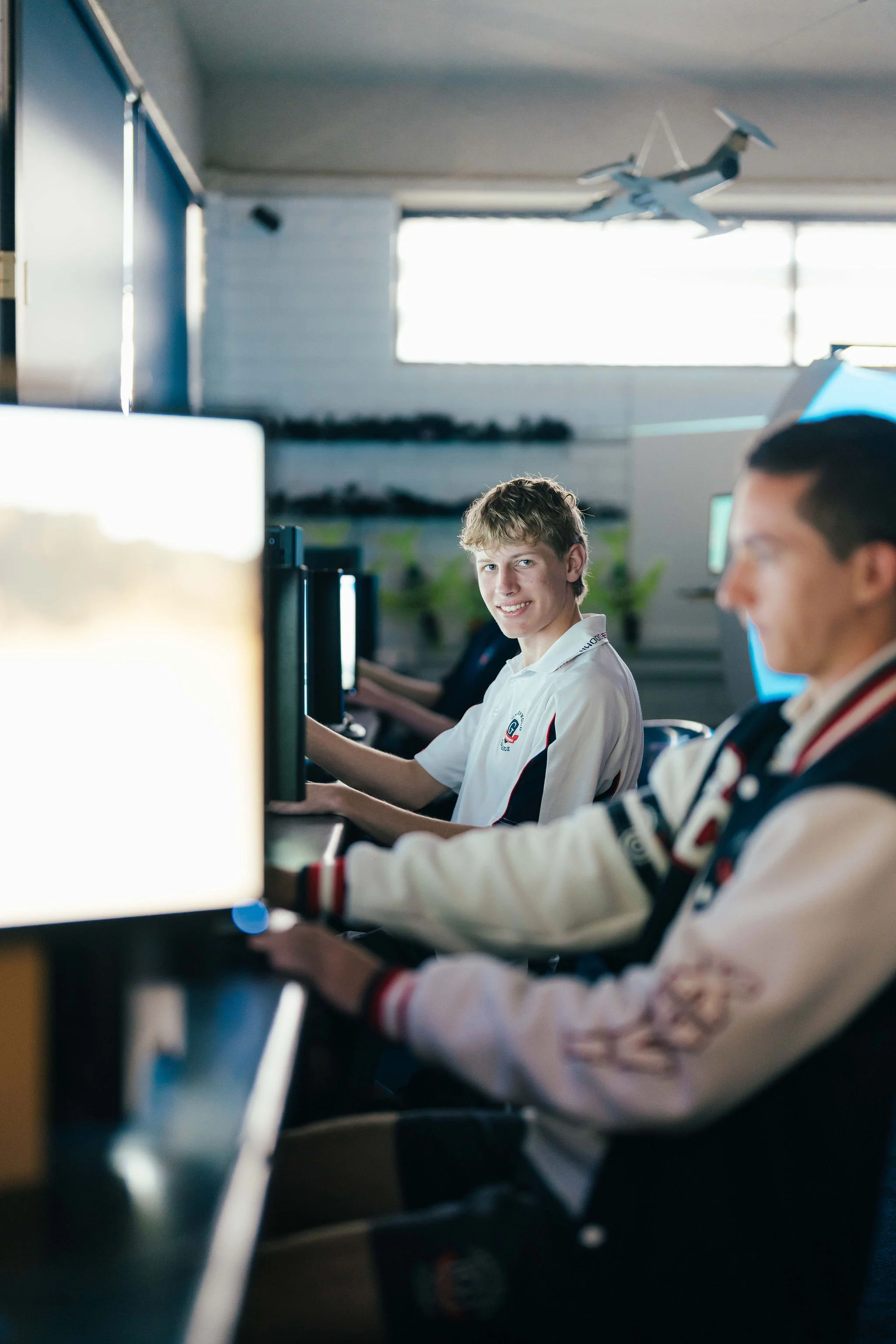 Young boys sitting at computer desks in a classroom, working on computers.