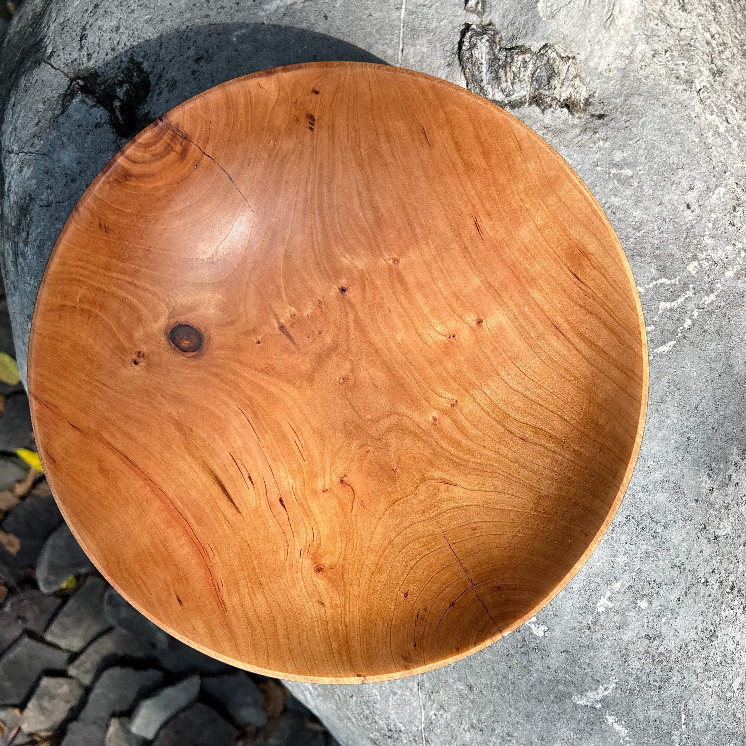  I have a stock of cherry in the US which allows for much large bowls than typically turn in France. This one is 11” in diameter, 2 ½” high to the rim, and 2 ⅛” deep at the center. Despite its heft growing half way down from the rim, the bottom is da