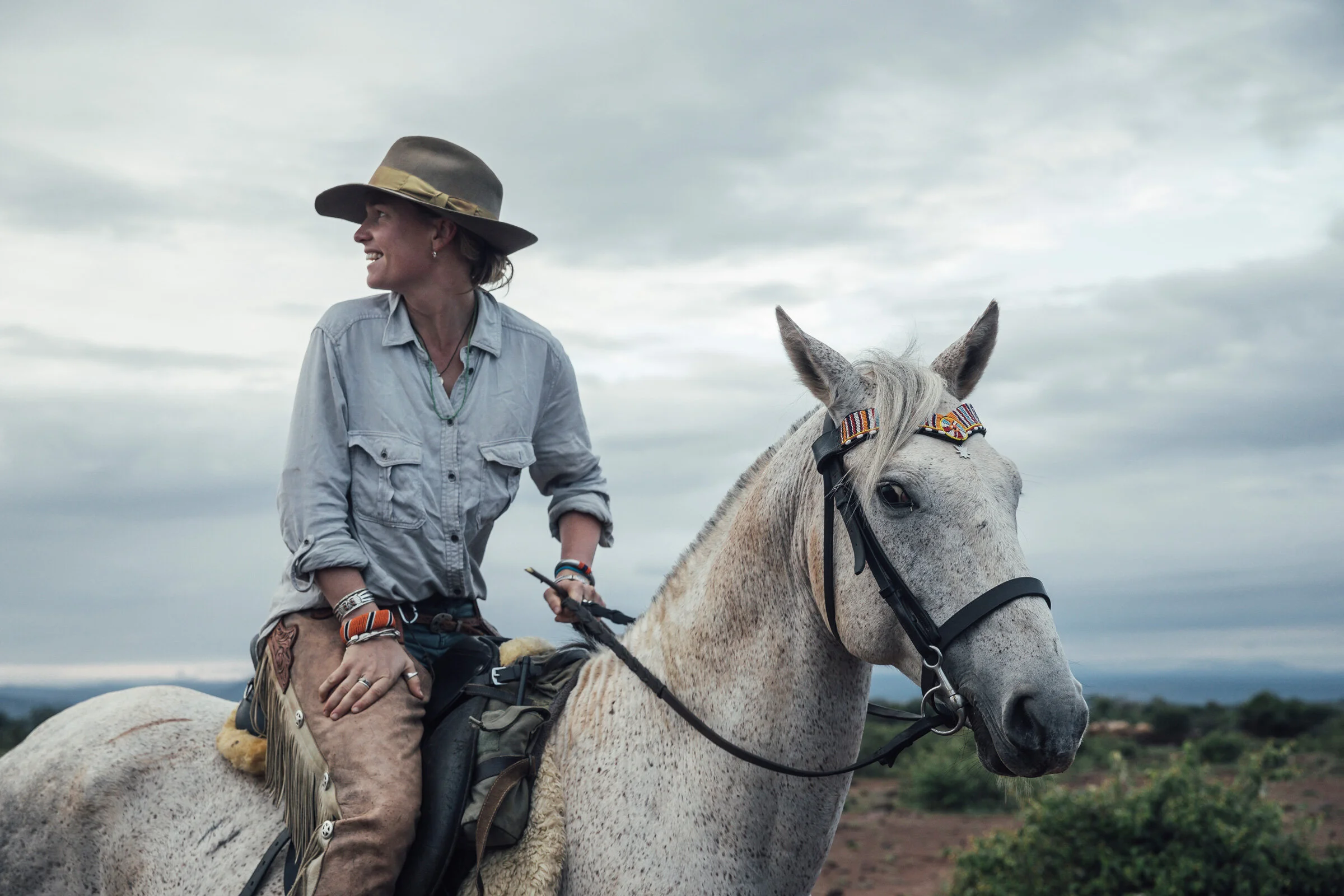 Rytter med bredbremmet hatt på en lys hest under ridesafari ved Ol Malo i Laikipia, Kenya.