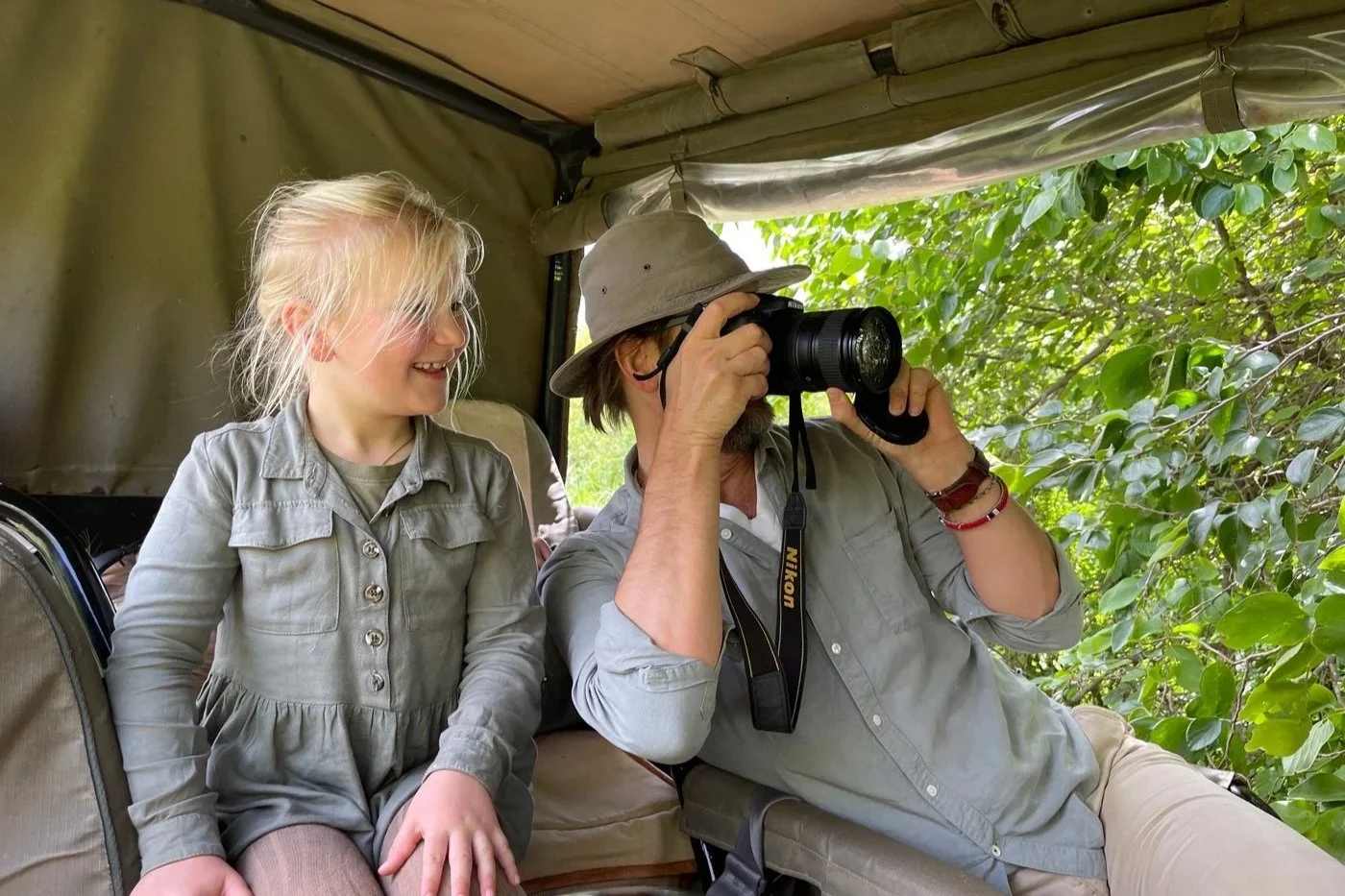 Far og datter på safari i Afrika med kamera, observerer dyreliv