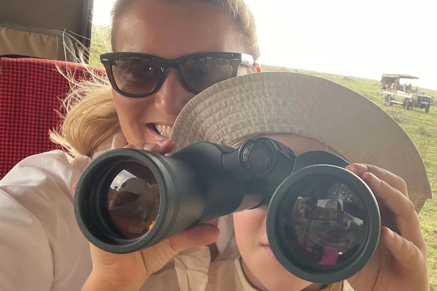 Familie på safari i Afrika som observerer dyreliv med kikkert