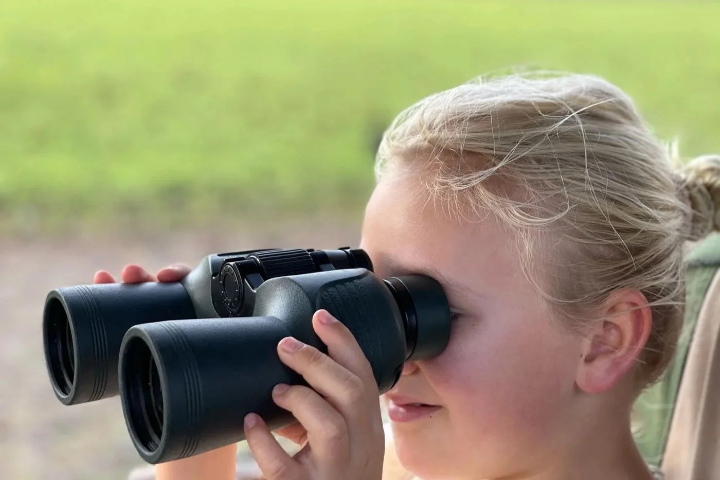 Barn ser på dyreliv med kikkert på safari i Afrika