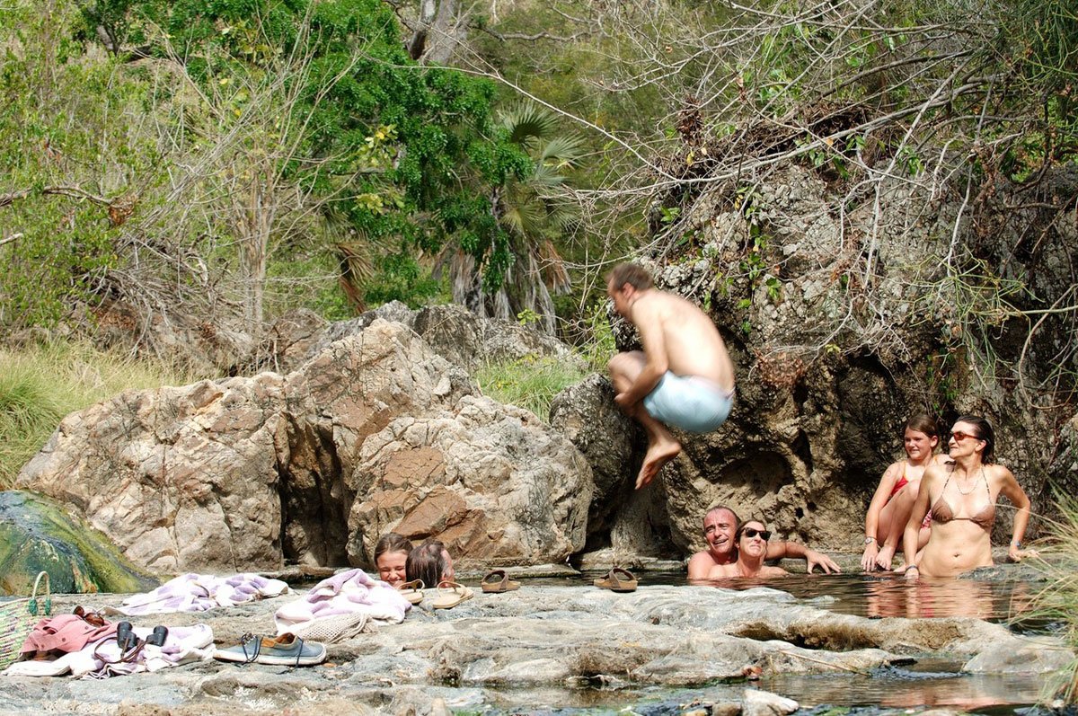 Gjester bader mellom klipper ved varme kilder på en utflukt fra Sand Rivers i Nyerere nasjonalpark.