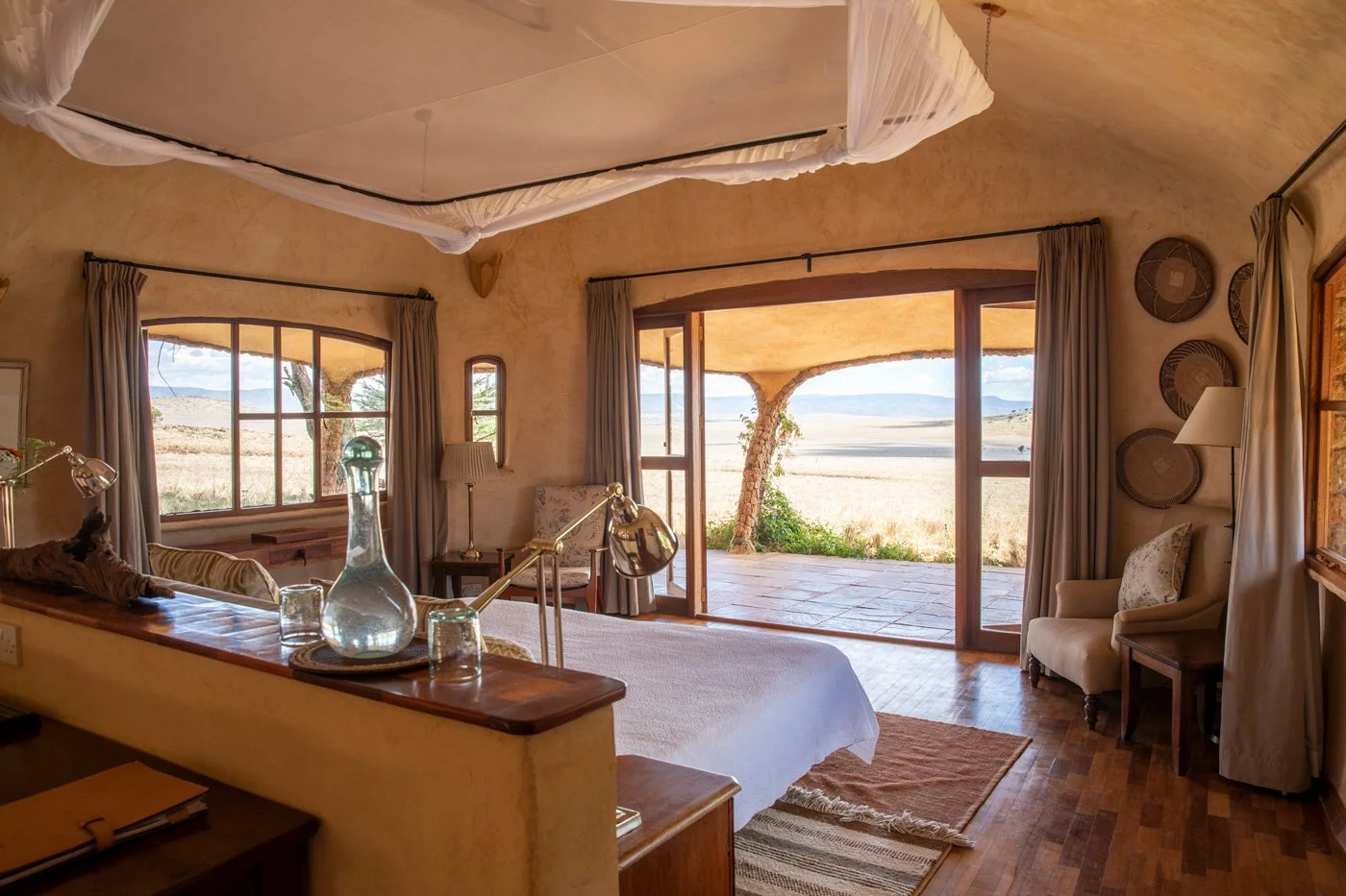 Soverom i en Earthpod på Lewa House med utsikt mot verandaen og det åpne landskapet.