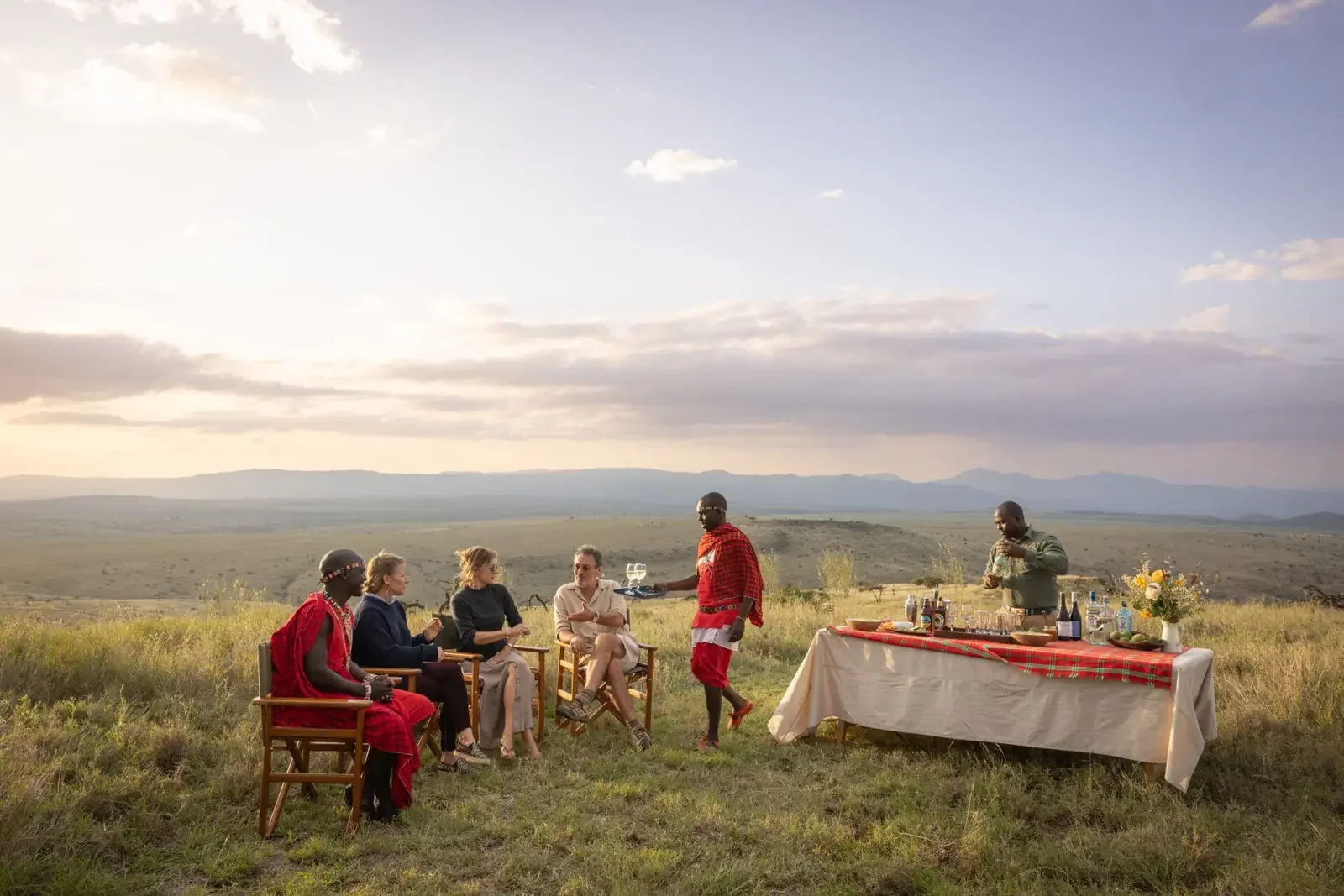 Safarigjester samlet på en åpen høyde med utsikt over landskapet i Lewa i Kenya.