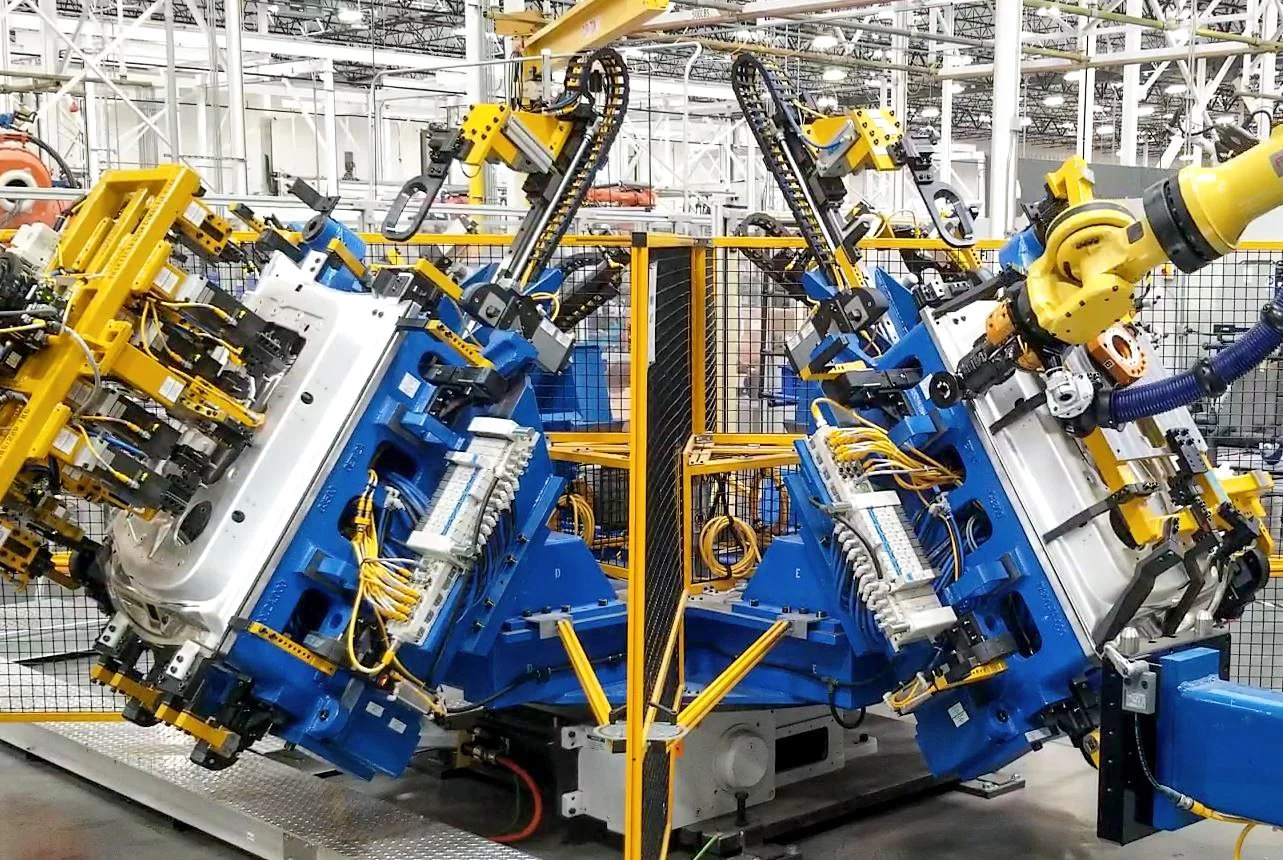 Robotic automation system assembling an automotive door structure on a vehicle manufacturing line.
