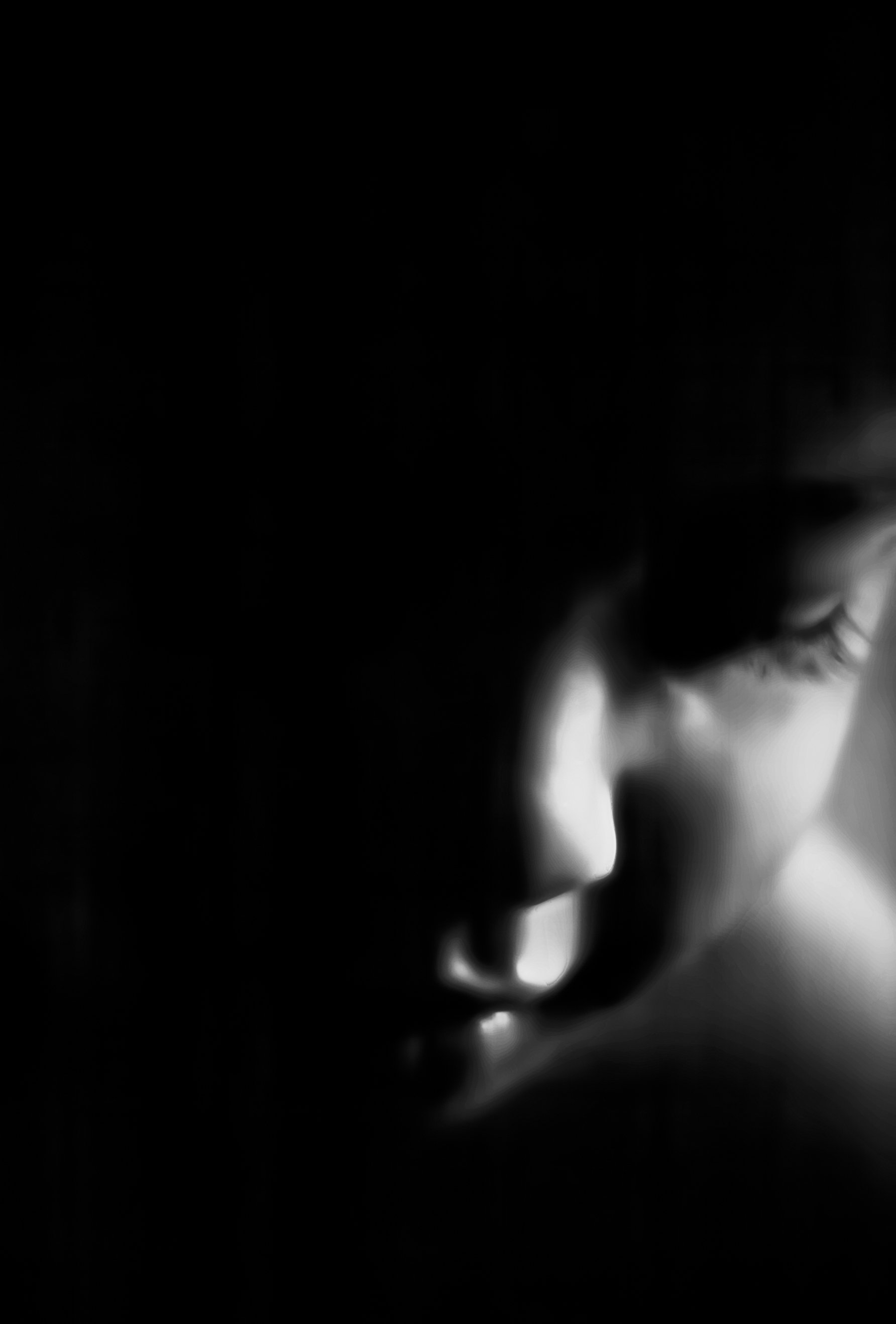Close-up black-and-white photo of a person's eye, focusing on the eyelashes and eyelid.