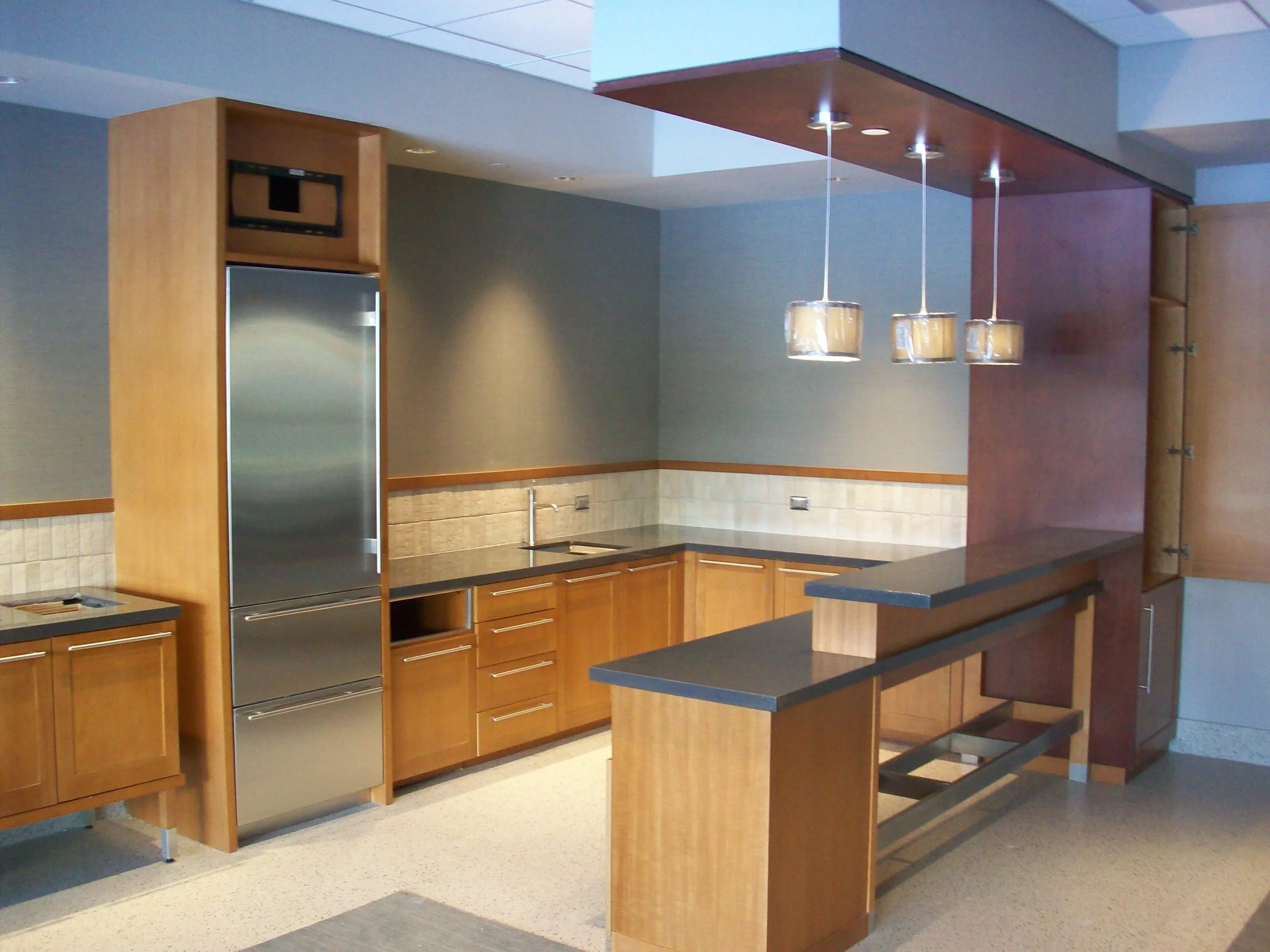 Kitchen area with fridge and cabinetry & millwork