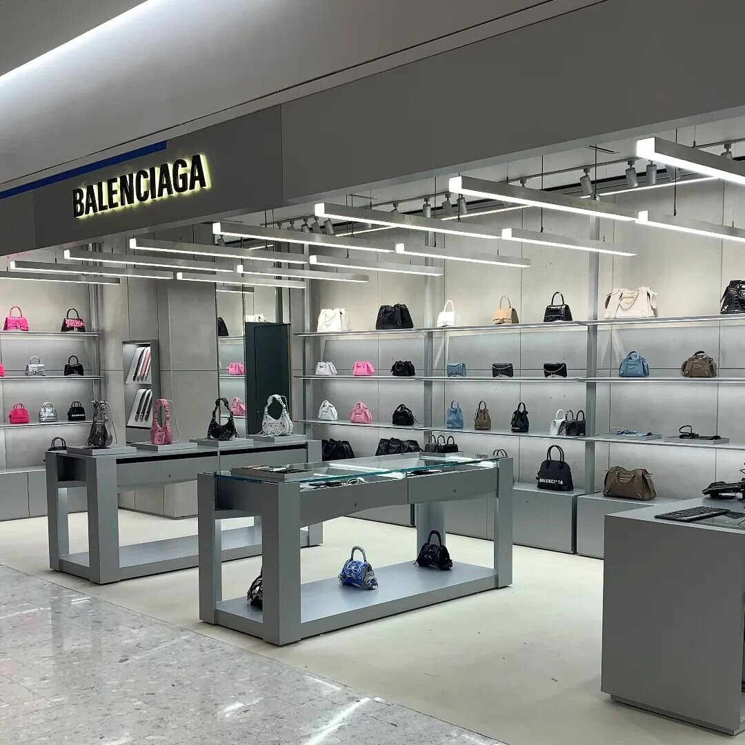 Photos of @mg_concepts millwork June '21 for #balenciaga @saks Bal Harbour shop, featuring concrete wall panels, illuminated floating wall shelves with base units, lacquered tables, mirrored door and halo lit logo sign. All highlighting beautiful pro
