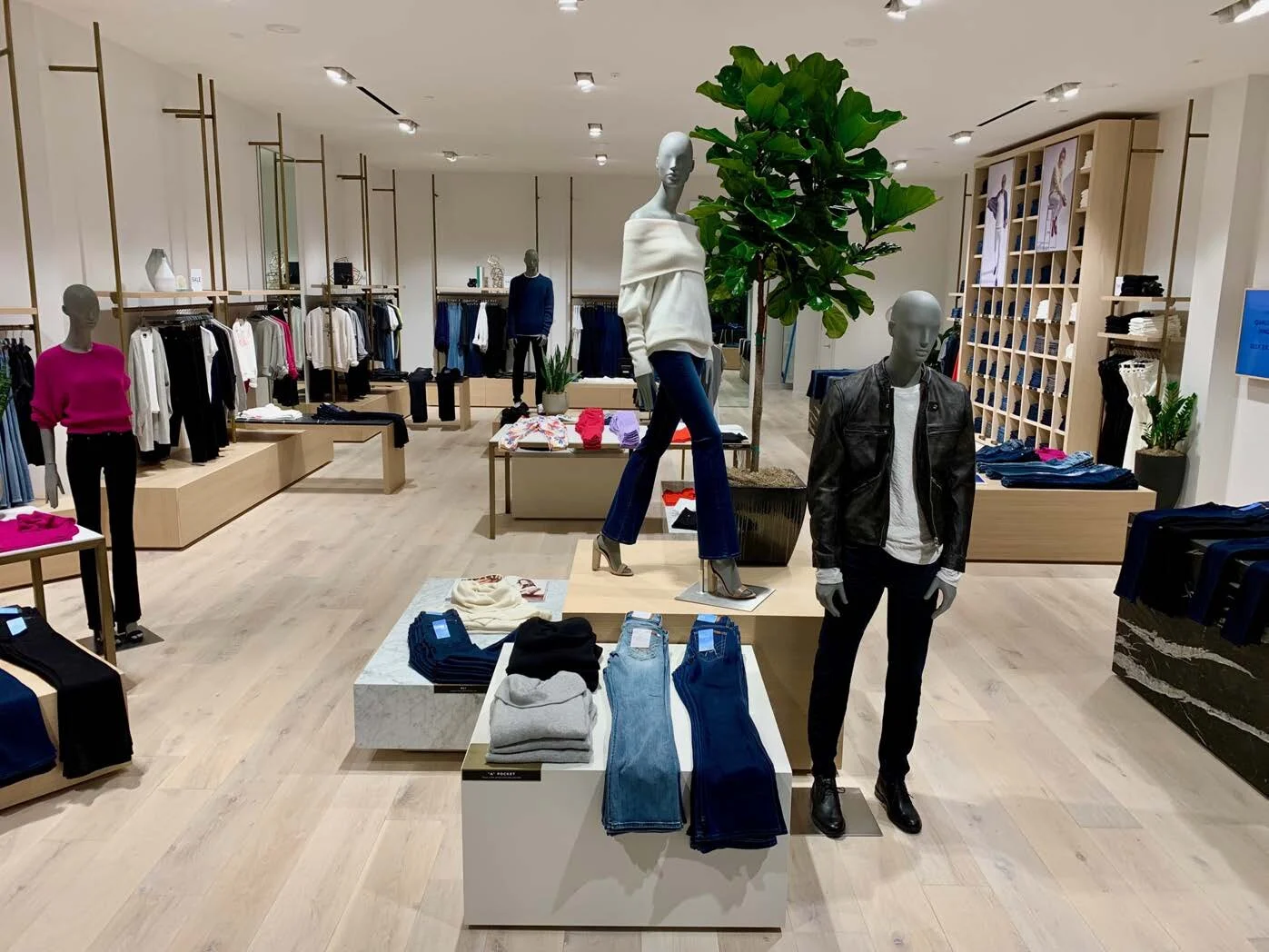 Retail interior straight on with clothing tables and clothing racks