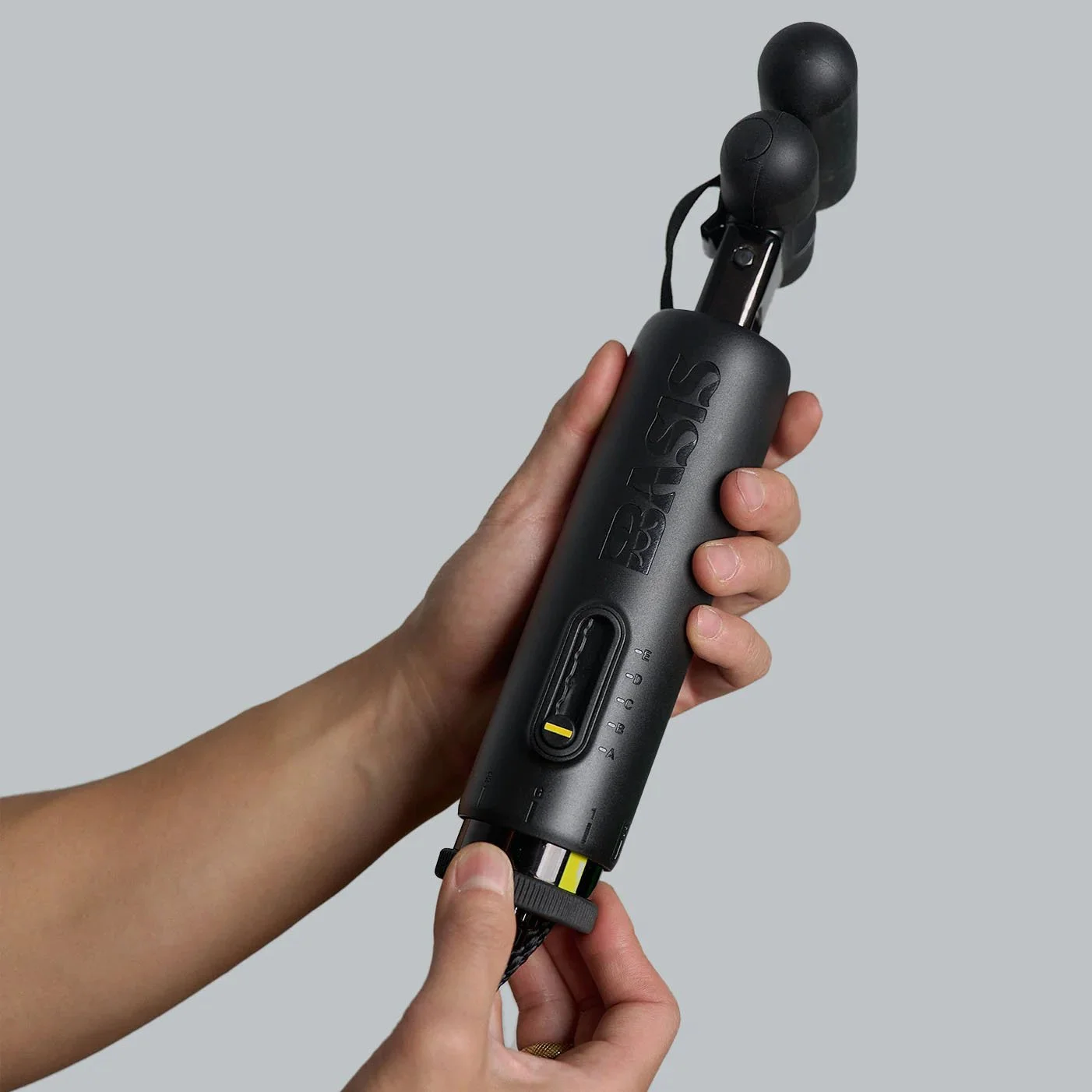 Basis Surf Paddle Trainer resistance unit held in hand showing compact size and adjustable resistance settings designed by DesignOther
