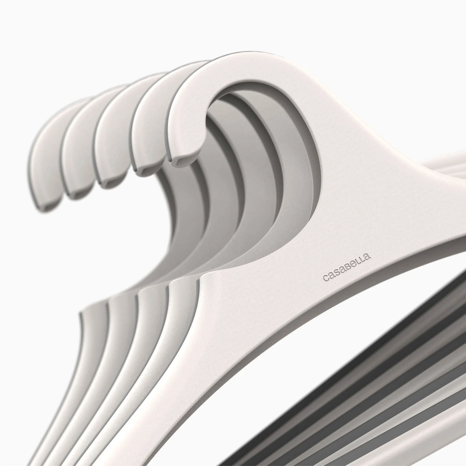 Close-up detail of multiple Casabella Nest Hangers showing the soft TPR overmolded top edge that prevents garment slippage and the stackable hook design