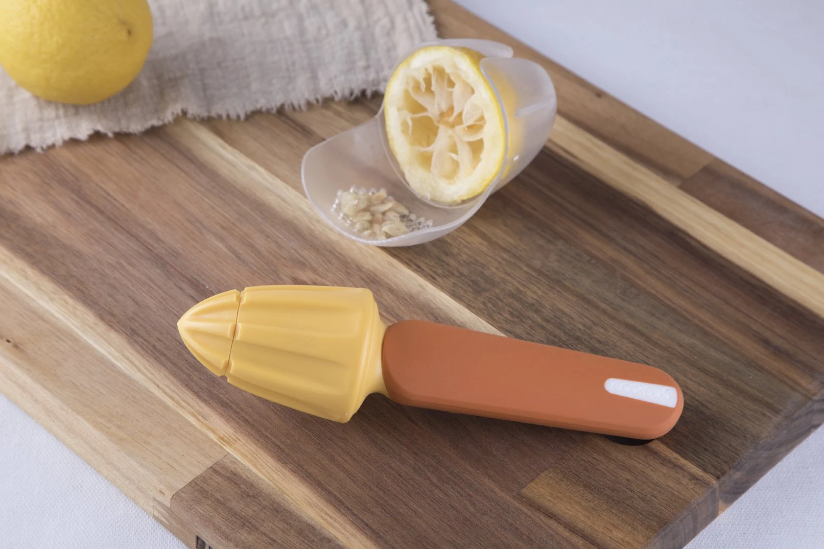 Cookduo Food Prep lemon reamer with a juiced lemon, showing the built-in straining system that catches seeds and pulp during juicing