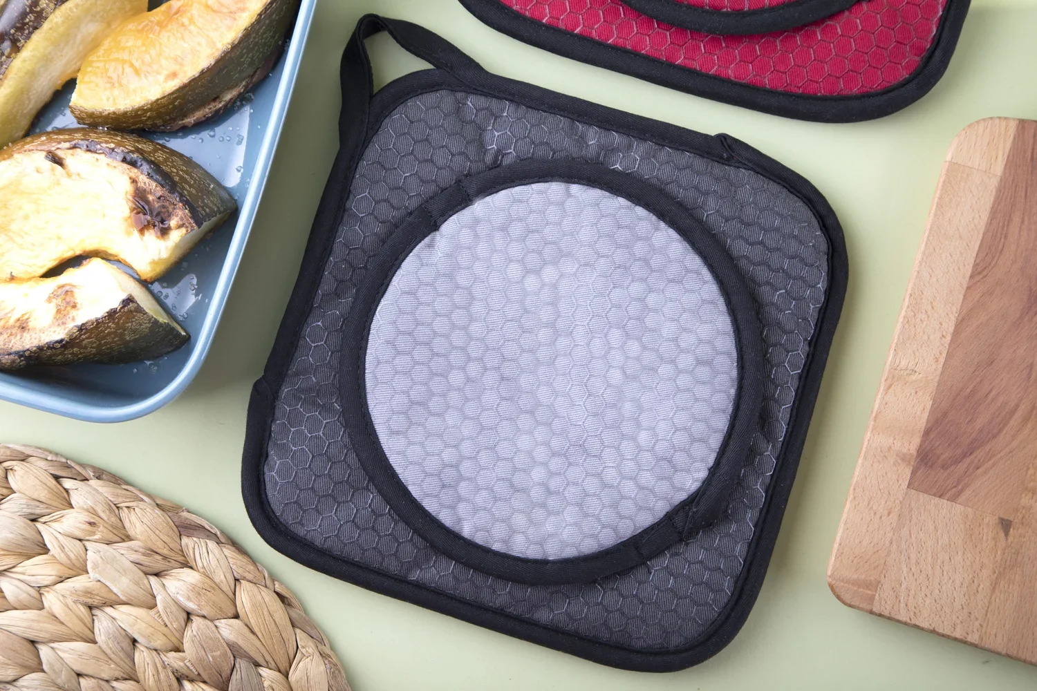 Gray Cookduo Grab and Grip pot holder showing the circular grip pad and silicone honeycomb pattern for precise, controlled handling