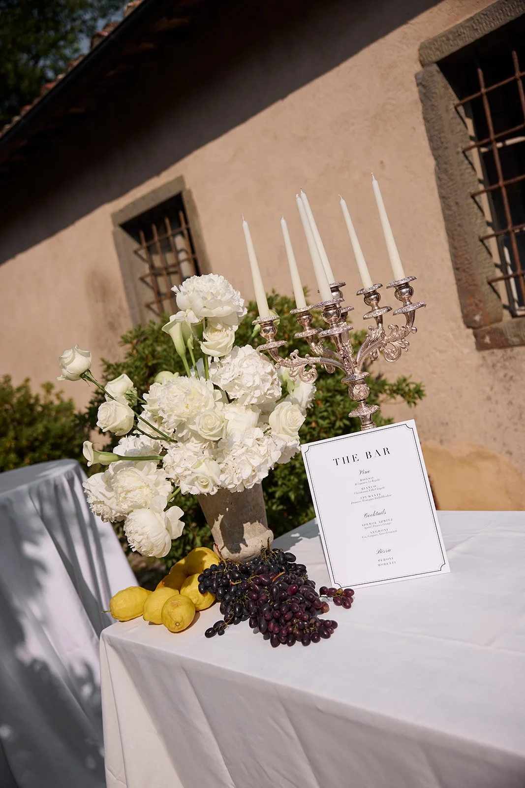 Timeless bar styling decor with candelabra, white florals, grapes and lemon styling