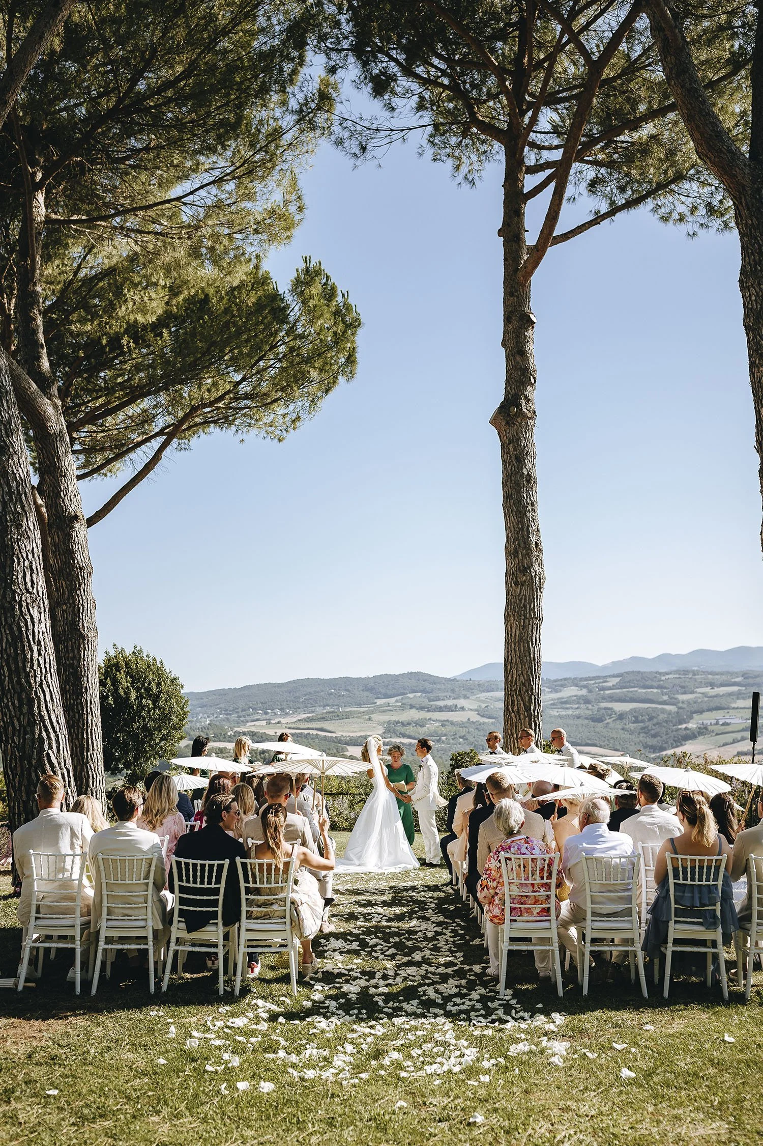 Outdoor wedding ceremony with panoramic views over the Umbrian valley at a historic monastery venue.