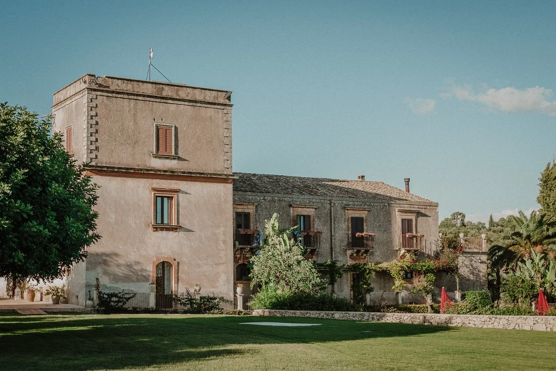 Exterior of Borgo del Carato, a restored fortified farmhouse wedding venue set within private parkland in the Monti Iblei hills of southeastern Sicily.
