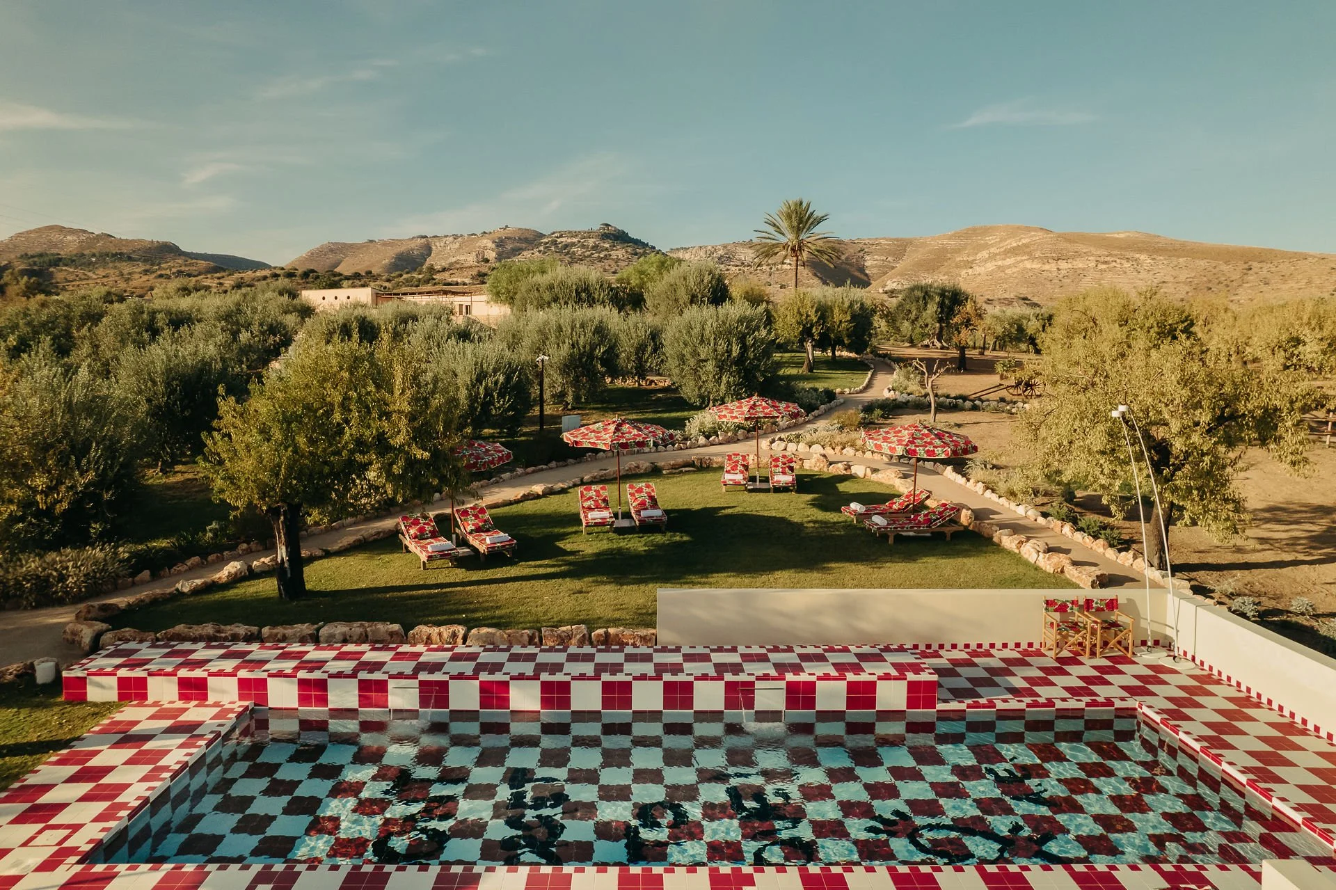 Outdoor swimming pool with matching sunbeds and parasols at Braccialieri, a newly opened luxury wedding venue near Noto, Sicily.