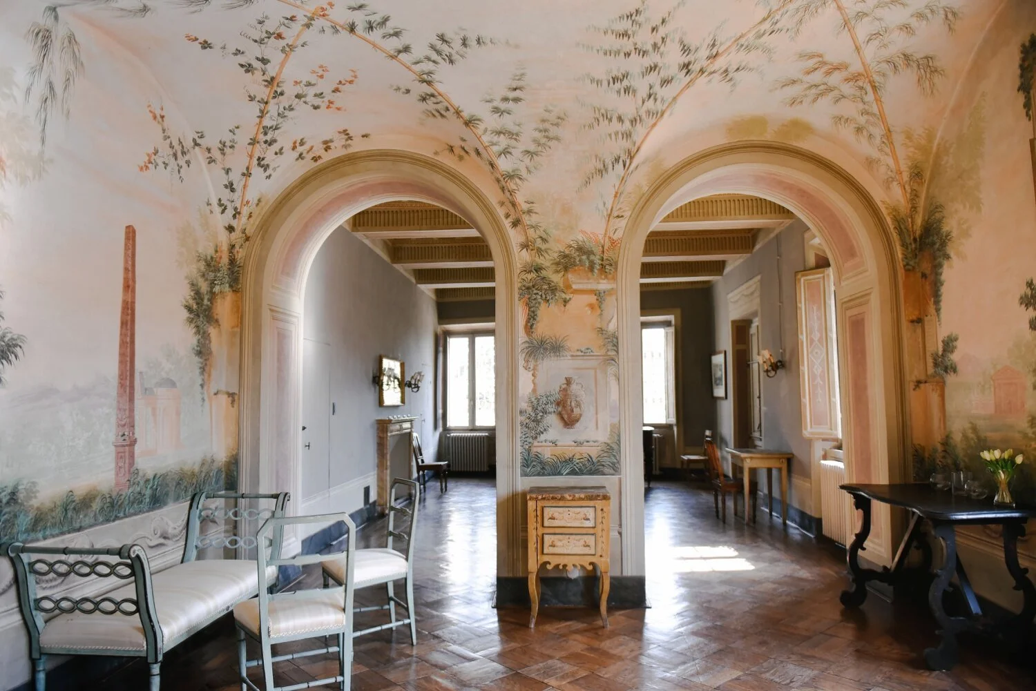 Ornately furnished interior room with hand-painted frescoed walls and ceiling at a Renaissance villa near Siena, Tuscany.