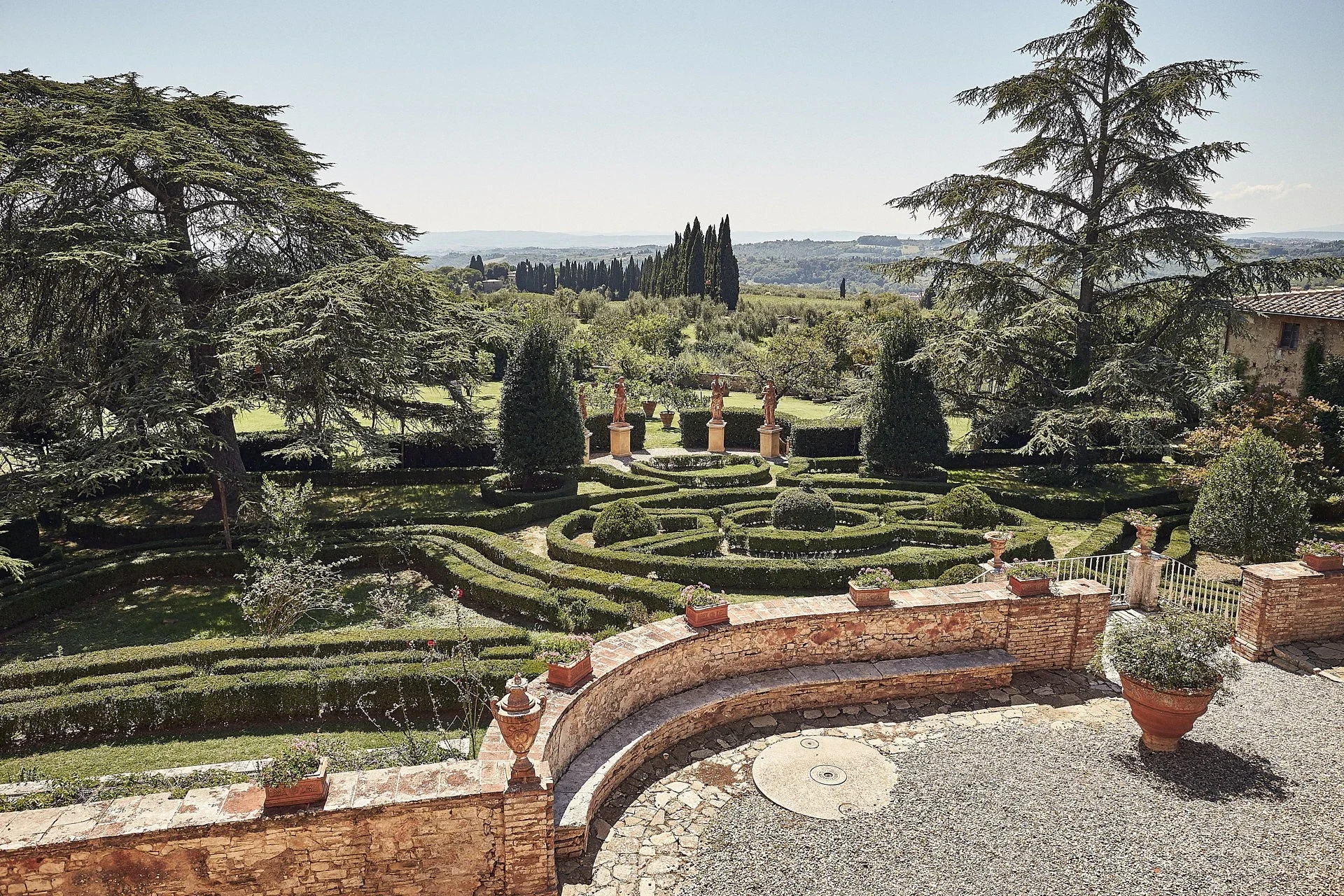 Formal sculpture gardens with manicured hedges at a historic Renaissance estate in the Chianti Classico region near Siena, Tuscany.