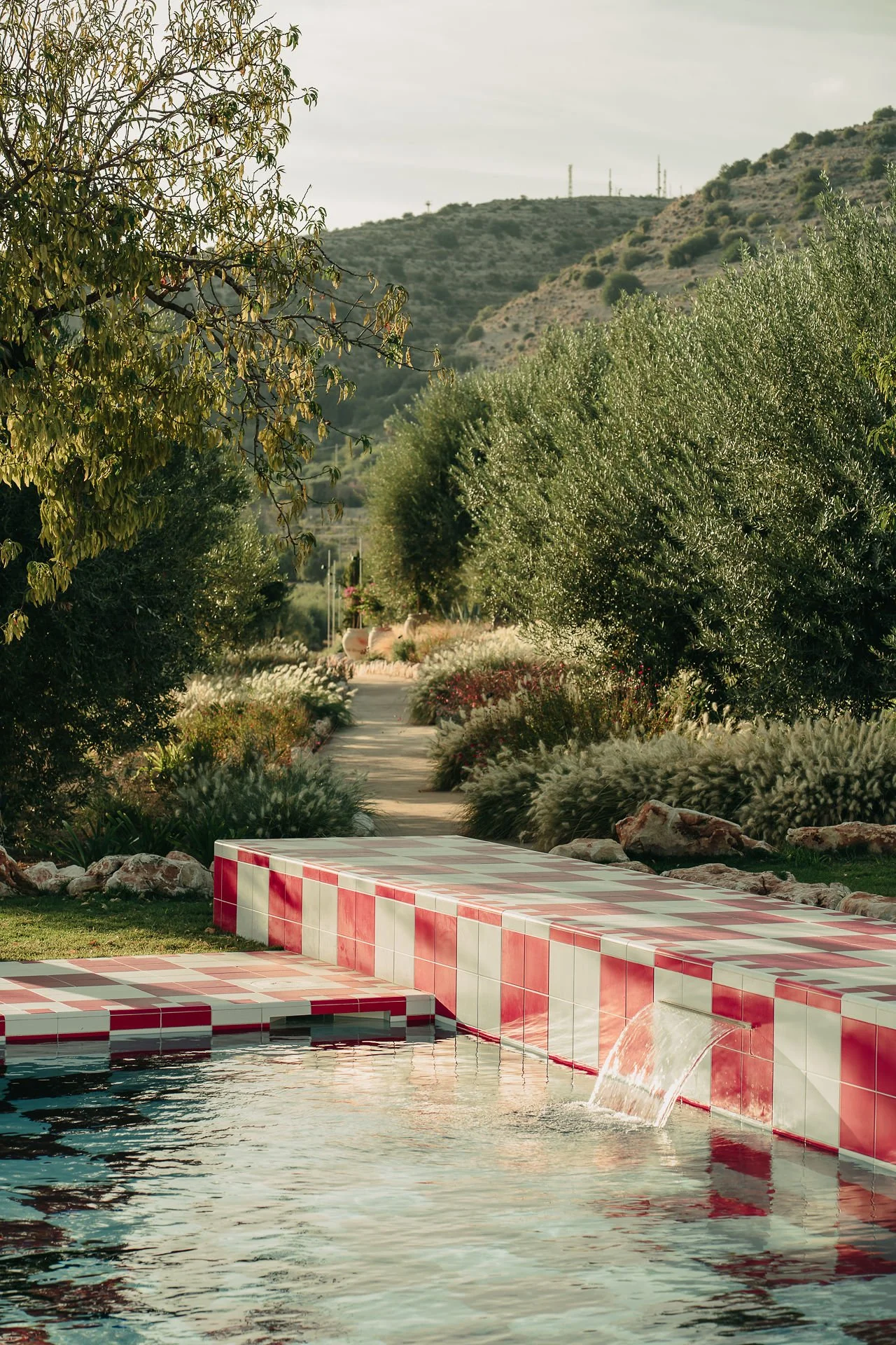 Close-up of red and white ceramic pool tiles at Braccialieri, a luxury wedding estate near Noto, Sicily, restored from an 1800s property.