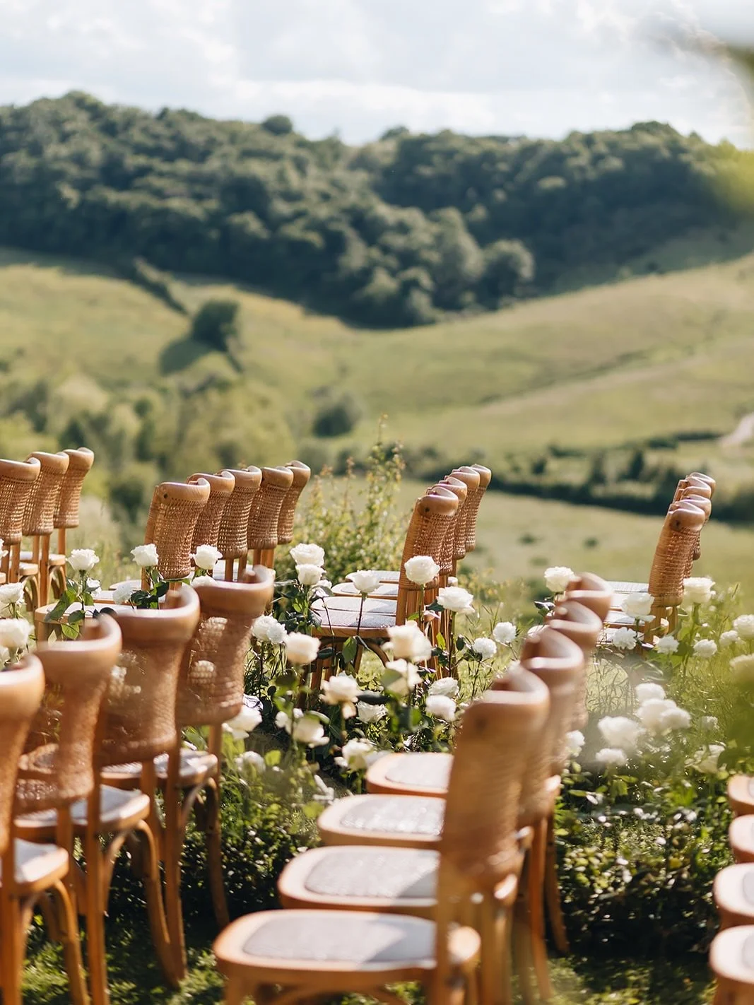 Outdoor wedding ceremony set up on a hilltop terrace overlooking the Crete Senesi landscape, Tuscany.