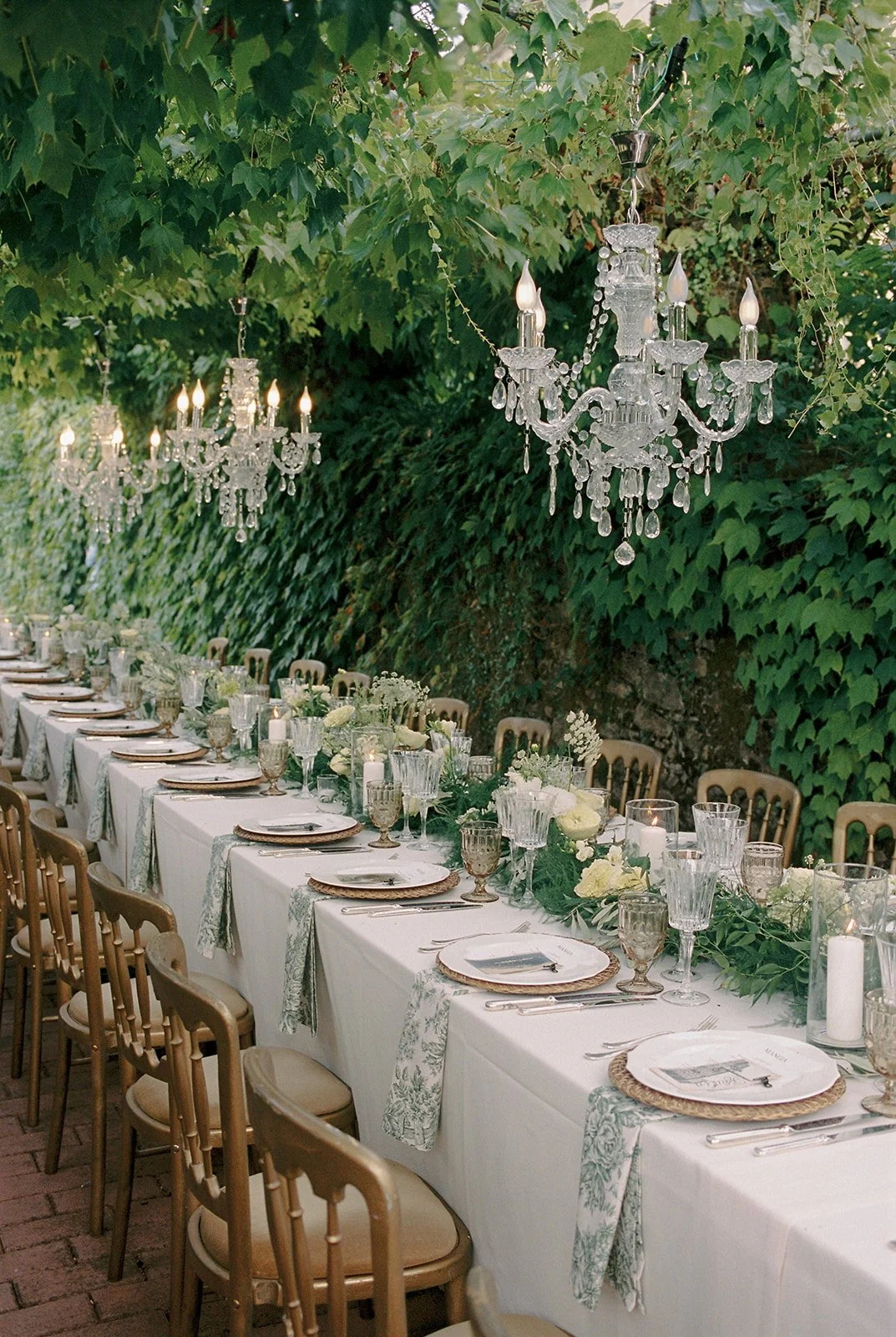 Al fresco dining with green and white florals and decor at Tuscany wedding at Villa Michaela