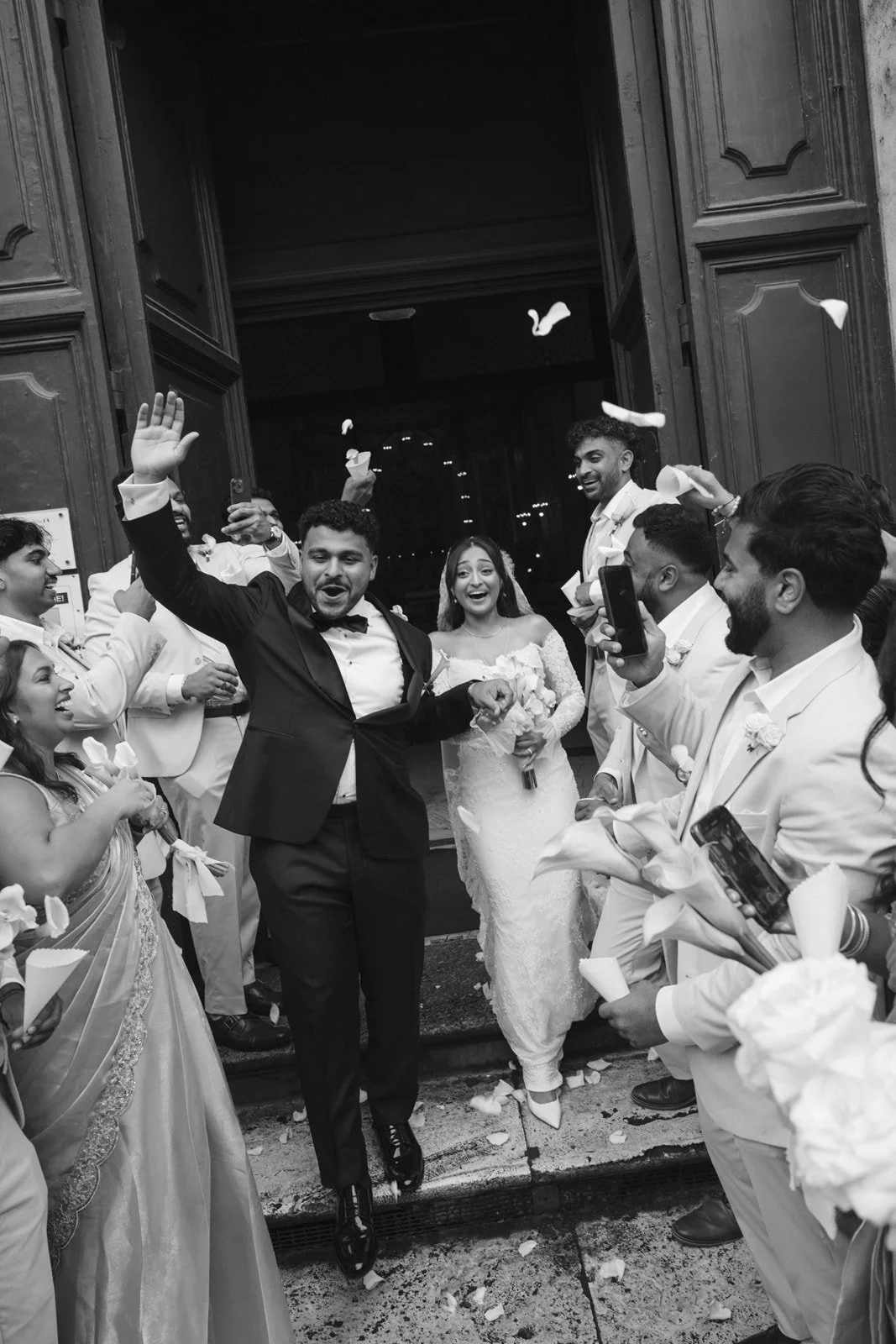 Newlyweds emerging from a Roman Catholic church in Rome to a cheering crowd.