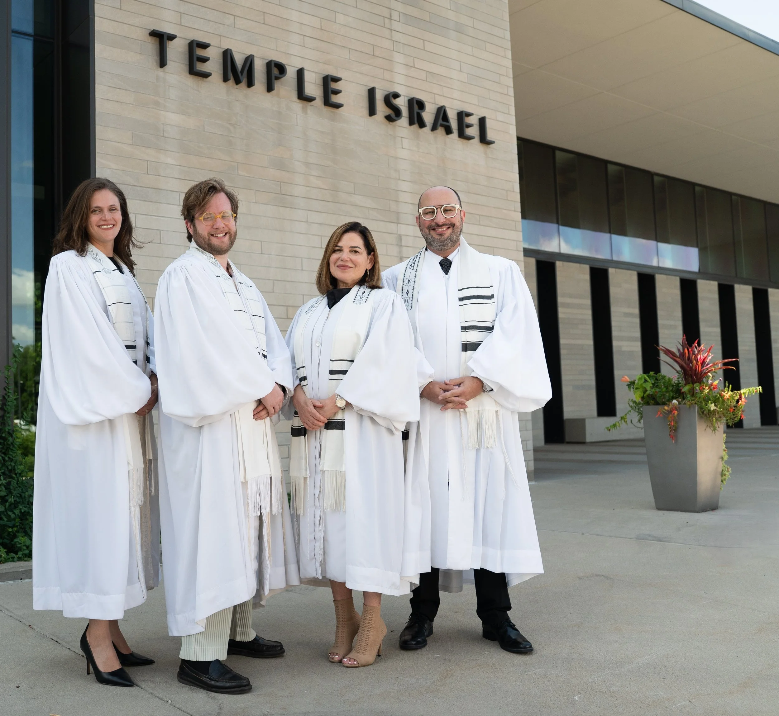 Rabbi Hartman, Alex Bonoff, Rabbi Zimmerman, and Rabbi Rodich stand outside Temple in white High Holy Day robes.