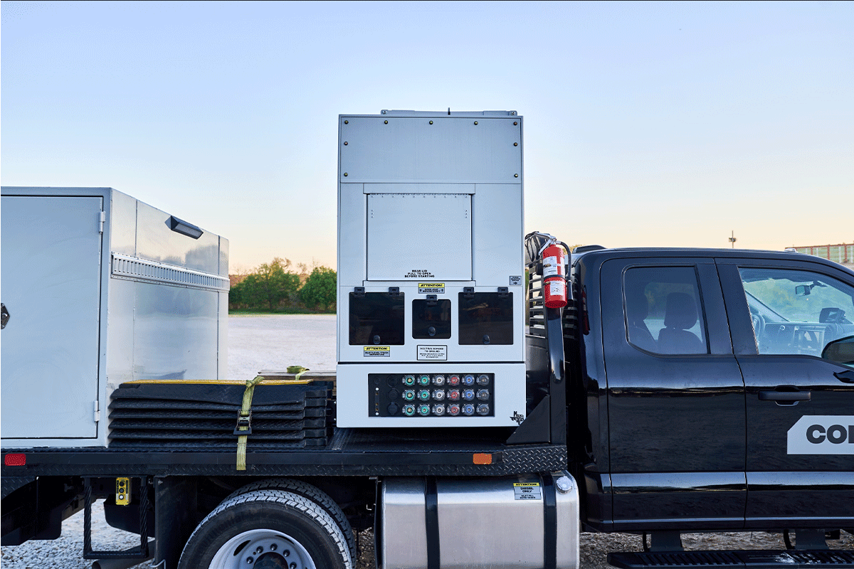 Crew operating a remote camera mounted on a vehicle during sunset.