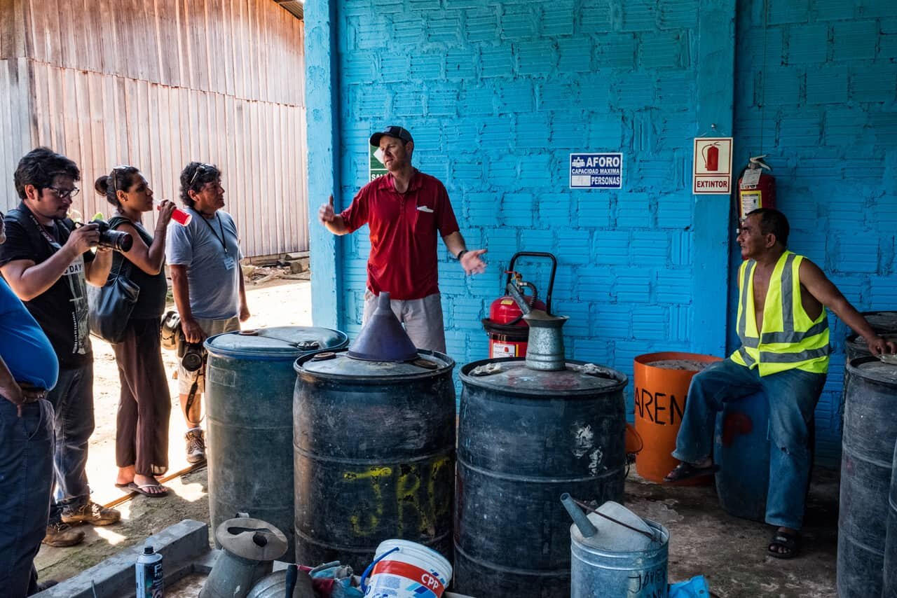 Expedition team members discuss import export logistics with a local businessman who wants to use the multimodal instead of planes to import gasoline. His business proposal would reduce the cost of gasoline from 28 soles / gallon to 18 soles, a sig