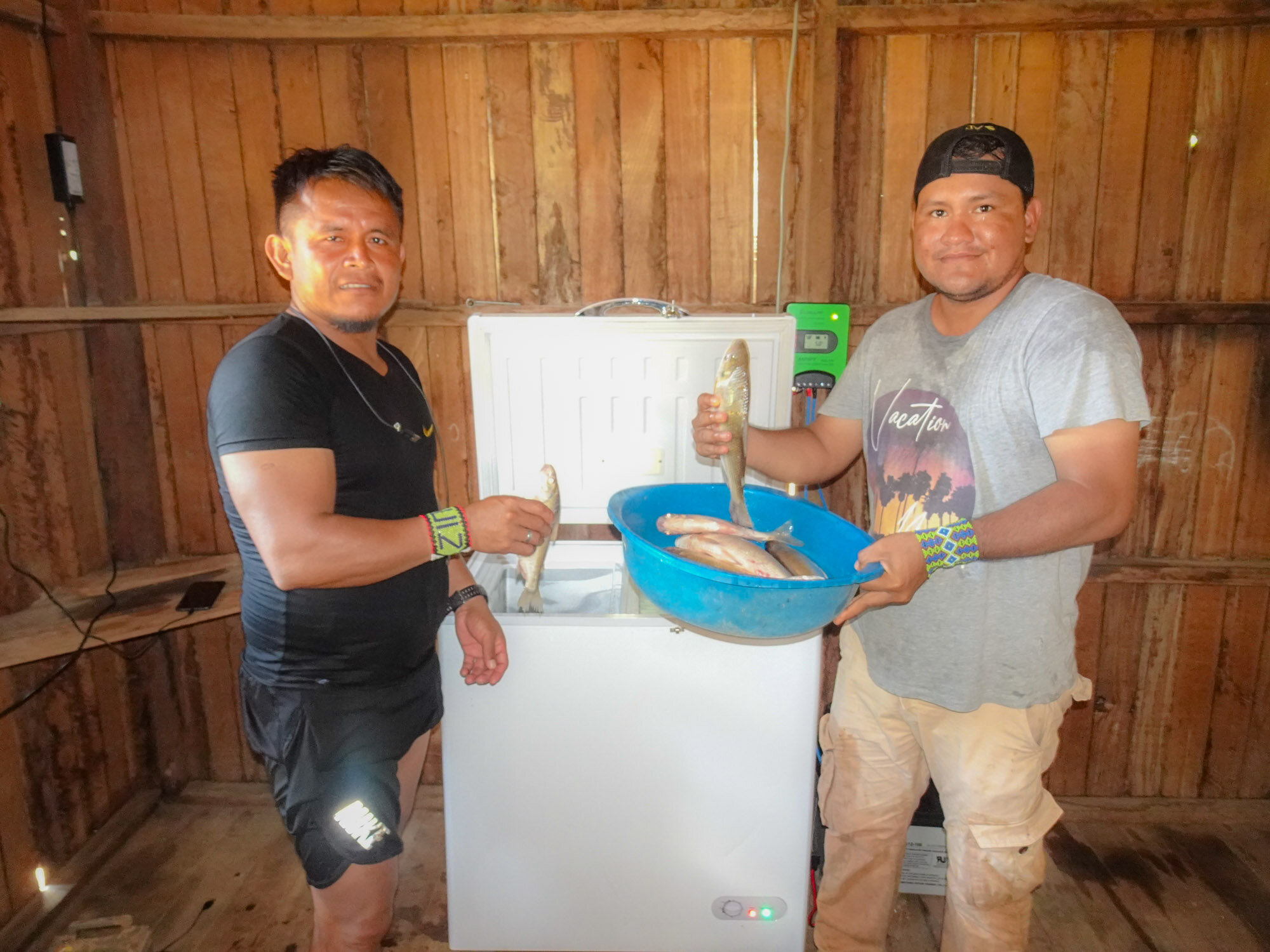   Jefe de Dulce Gloria, Arlindo Ruiz Santos, y especialista de campo Alto Amazonas, William Villacorta, mostrando el uso del refrigerador nuevo.  