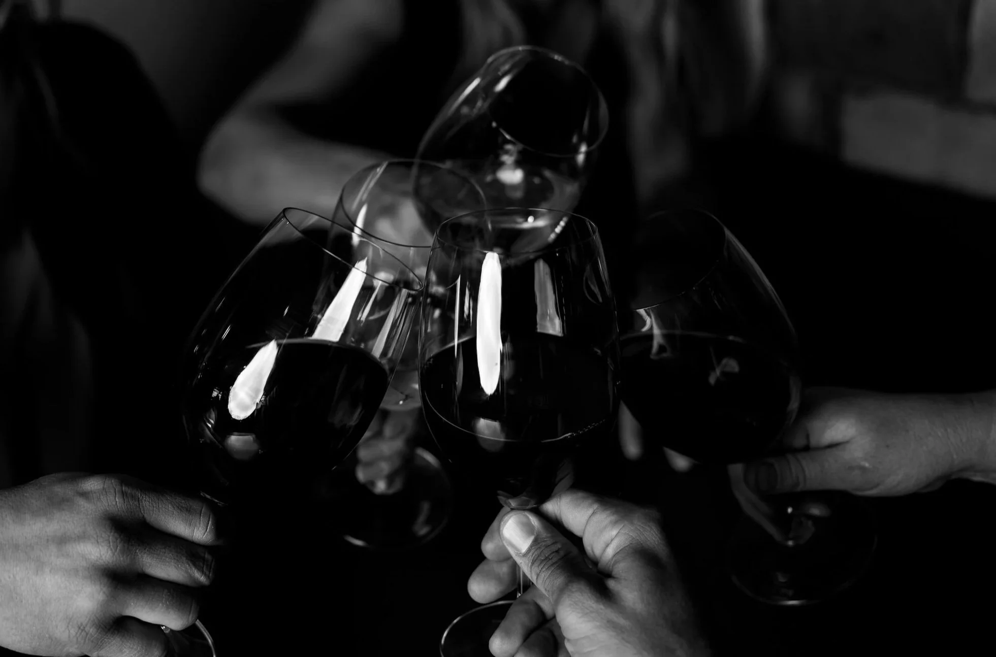 Group of people toasting with wine glasses in black and white