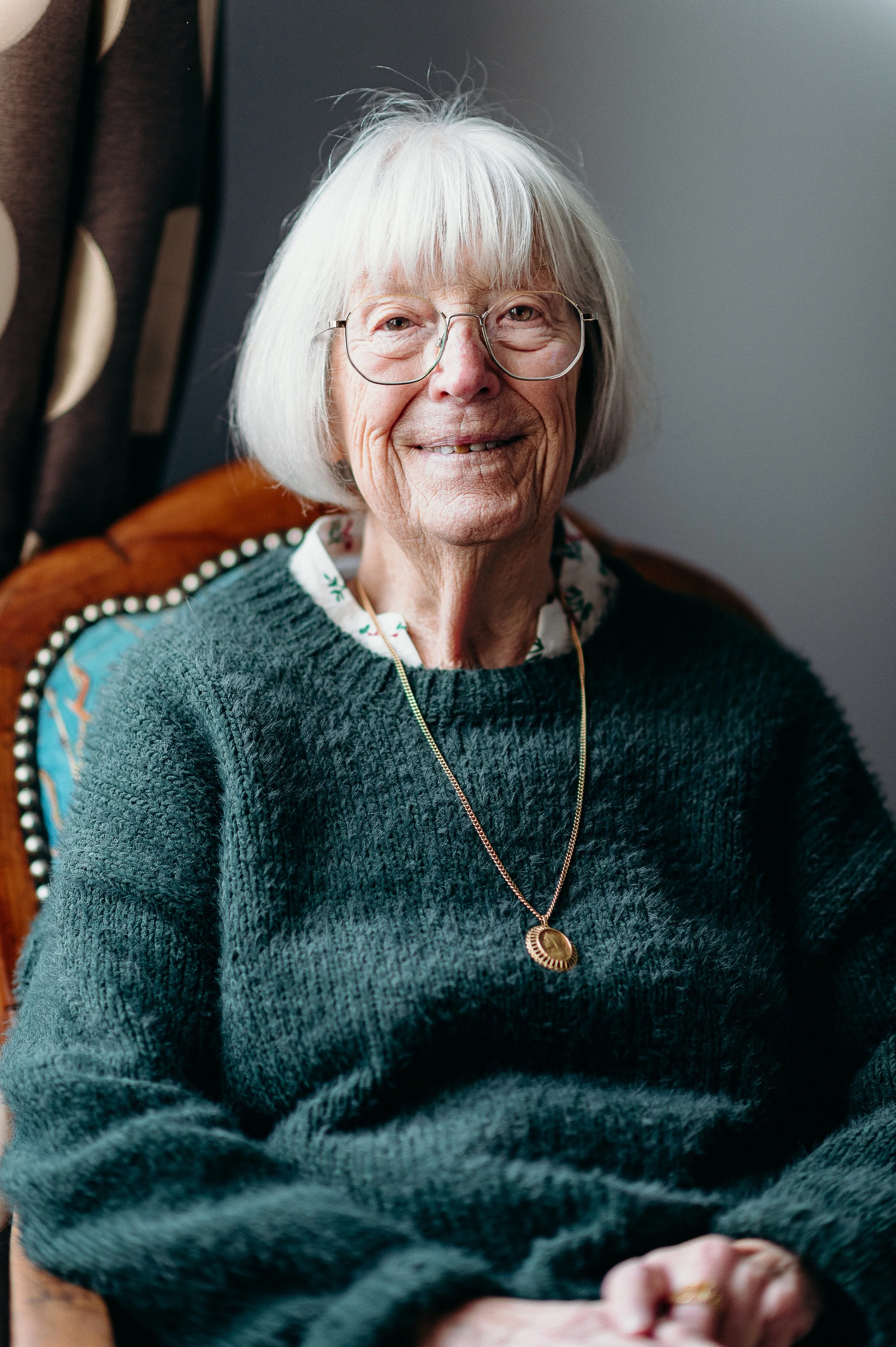 Séance photo famille à Bordeaux mettant en valeur un portrait souriant de la grand-mère dans la maison de famille