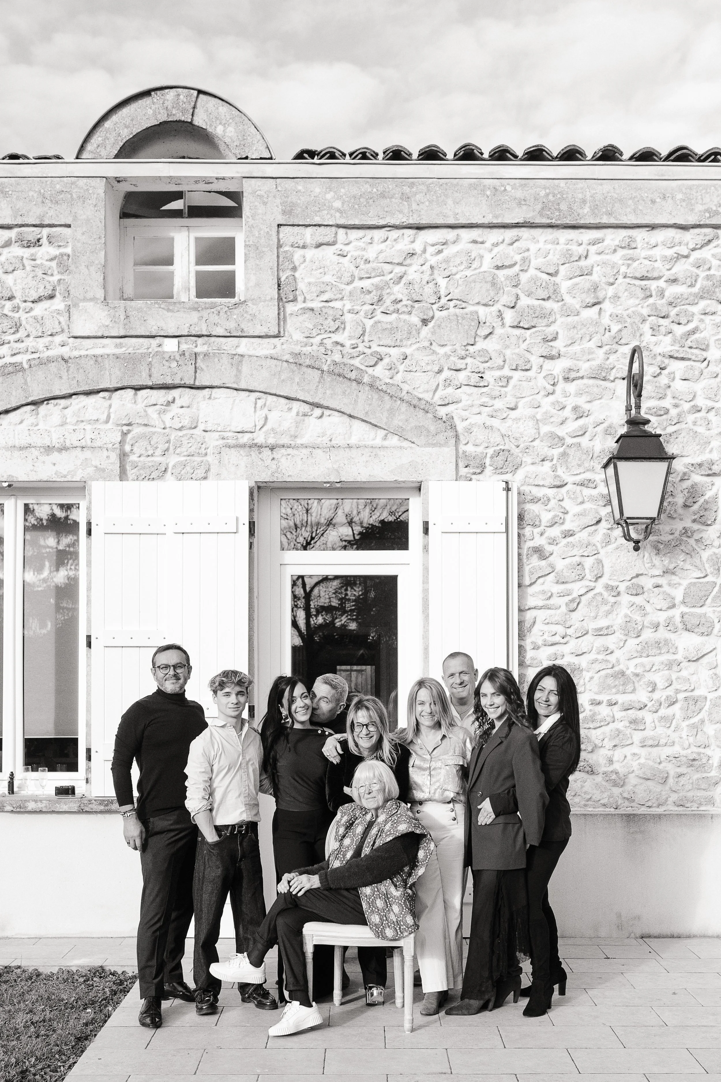 Photographe famille à Bordeaux photographiant une famille réunie devant la maison familiale en campagne bordelaise
