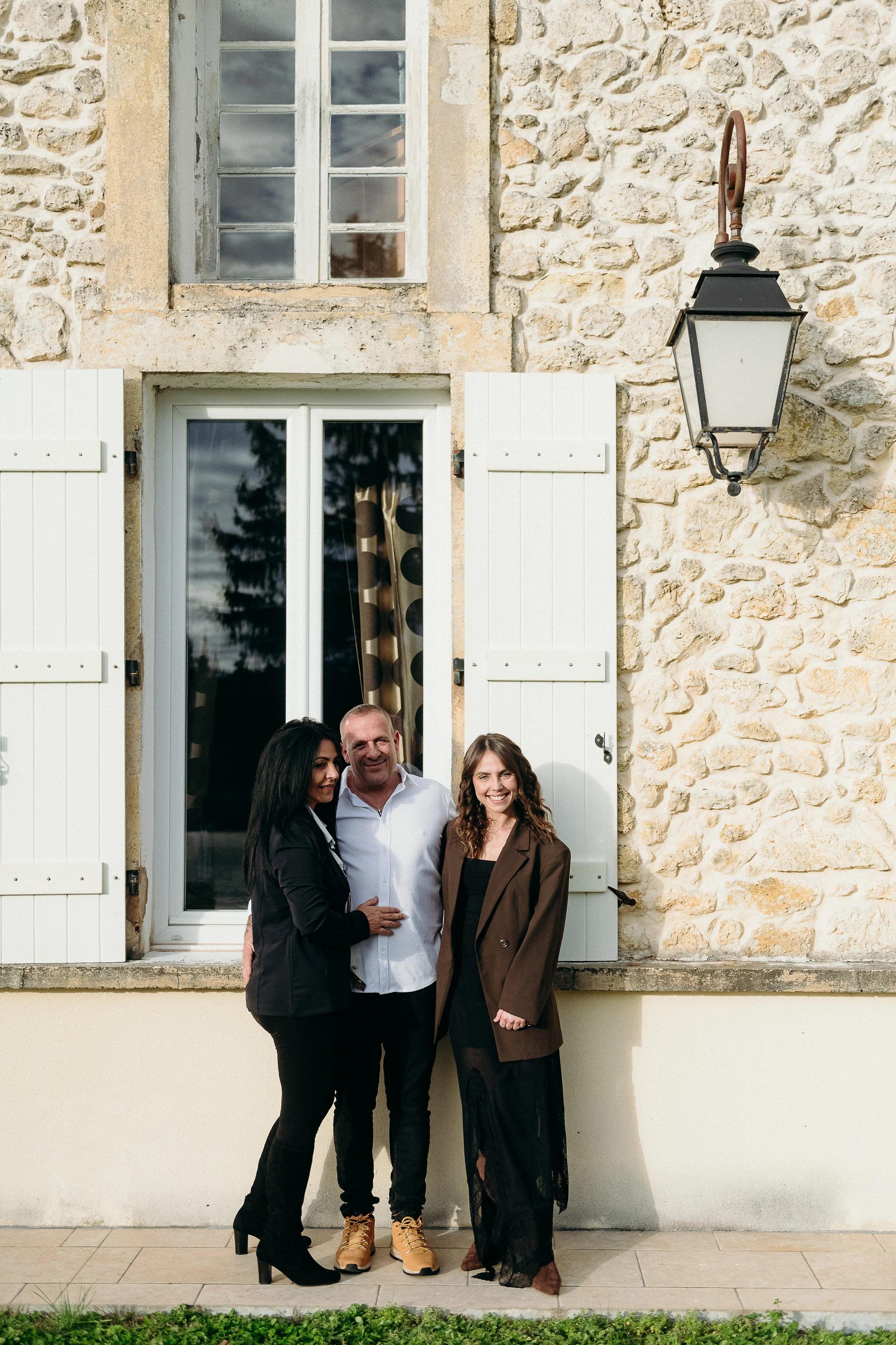 Séance photo famille à Bordeaux avec des membres de la famille posant devant la façade de la maison