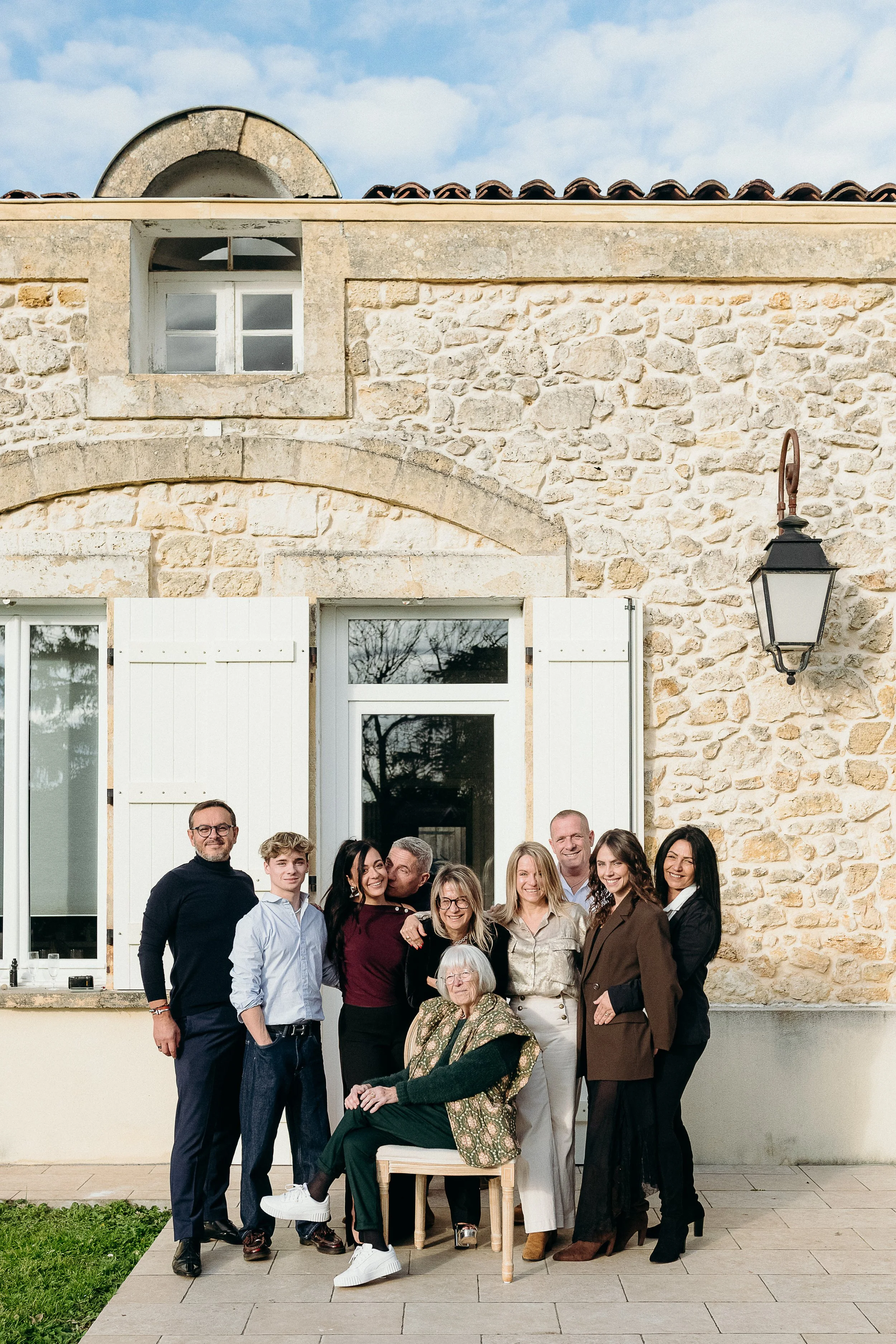 Séance photo famille à Bordeaux avec une grande famille réunie devant la maison familiale lors d’une réunion de famille