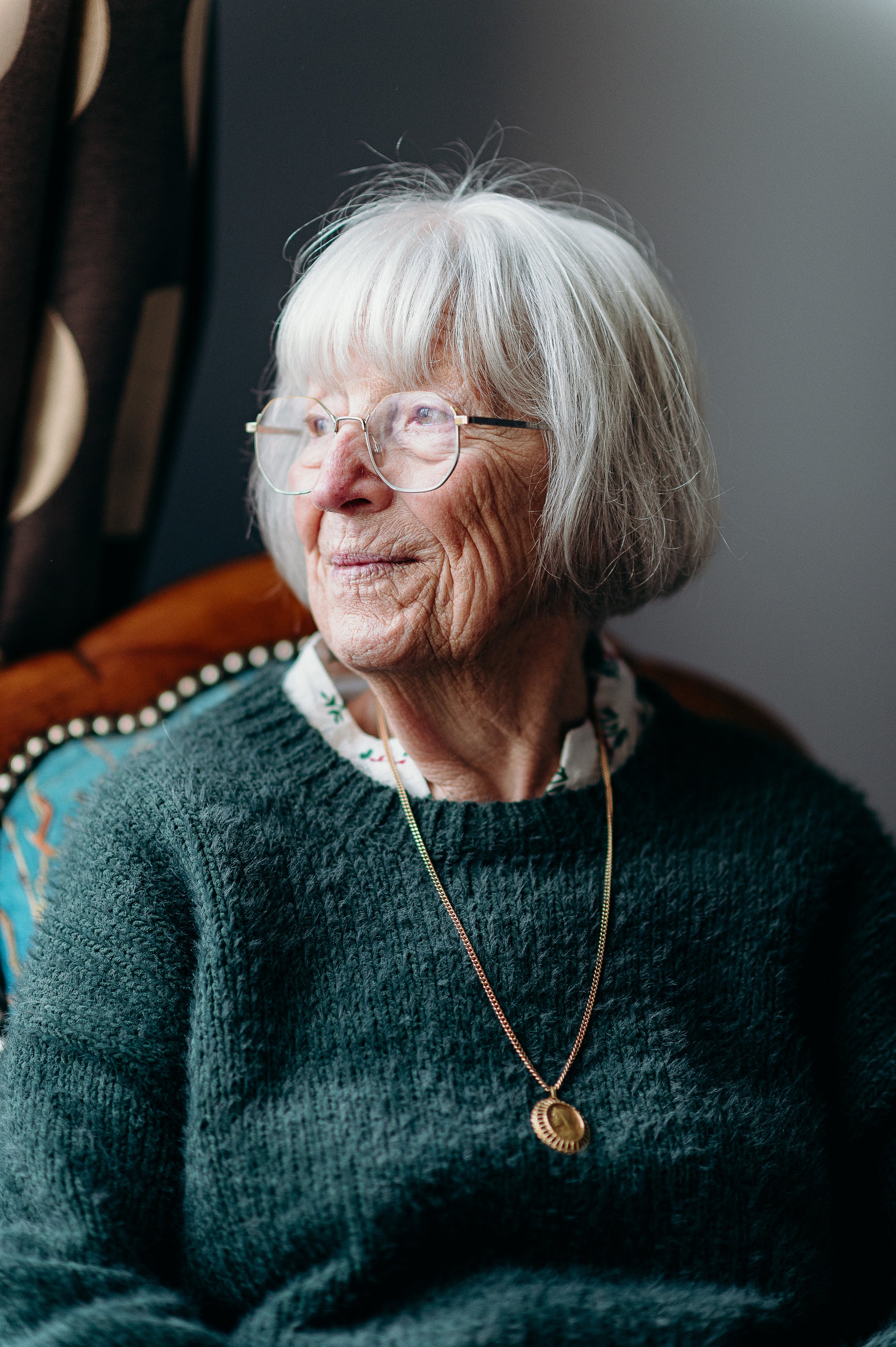 Photographe famille à Bordeaux capturant un portrait naturel de la grand-mère dans un fauteuil