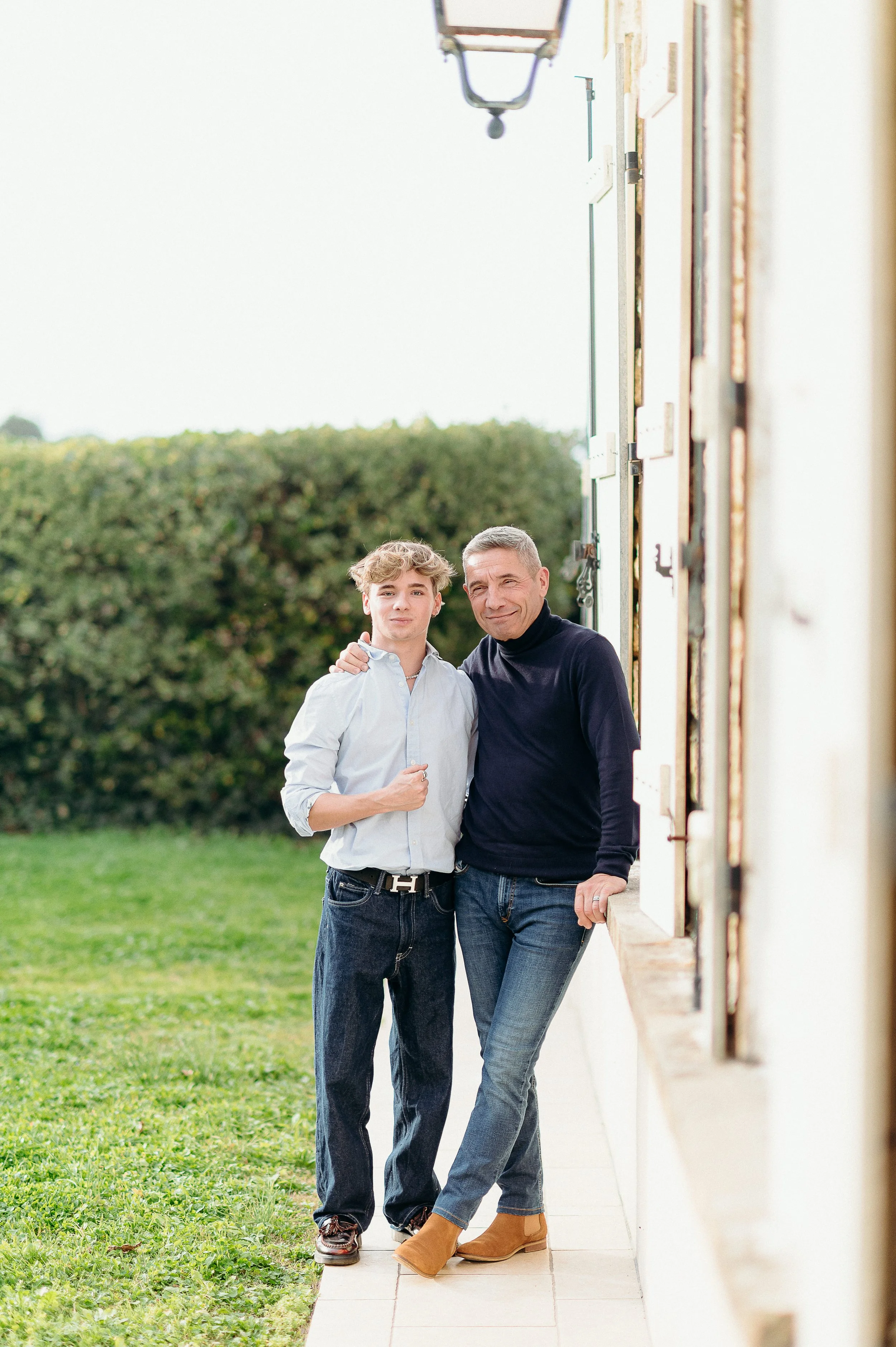 Séance photo famille à Bordeaux avec une fratrie adulte posant devant la maison familiale